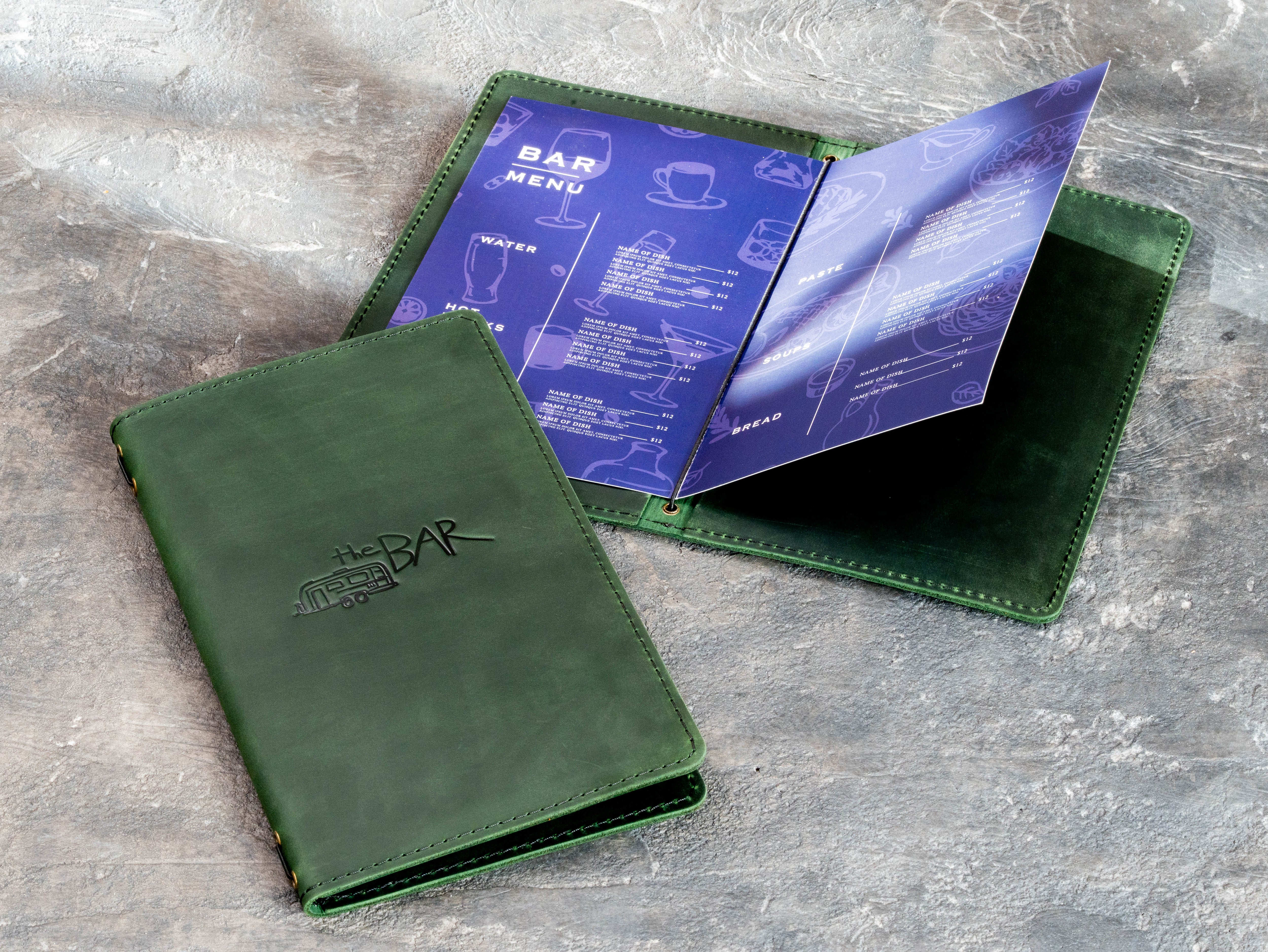 Green leather cocktail menu cover with elastic cord binding and printed menu pages.