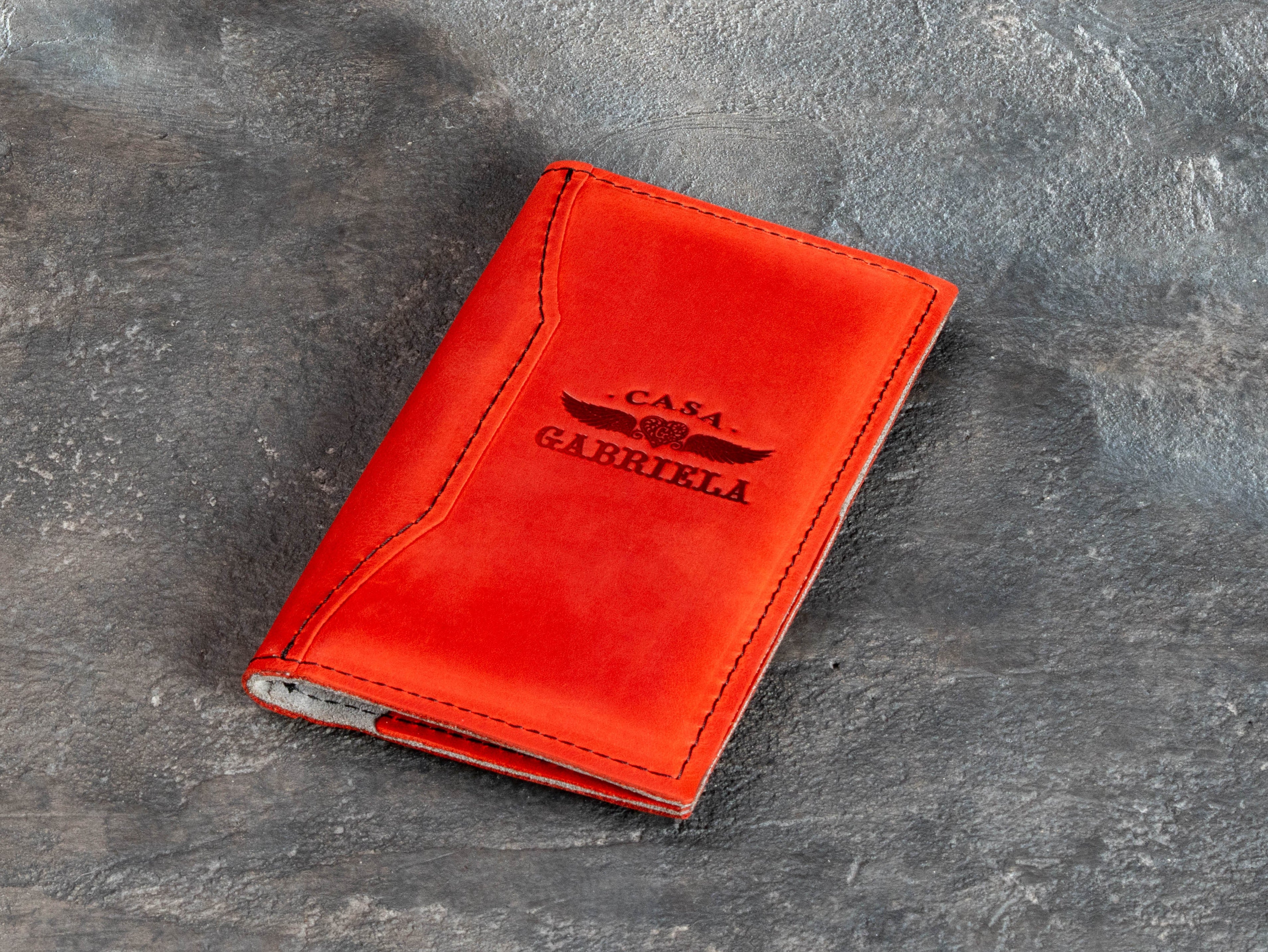 Custom red leather receipt presenter with restaurant logo, stitched cover, and compact Design #2 construction.