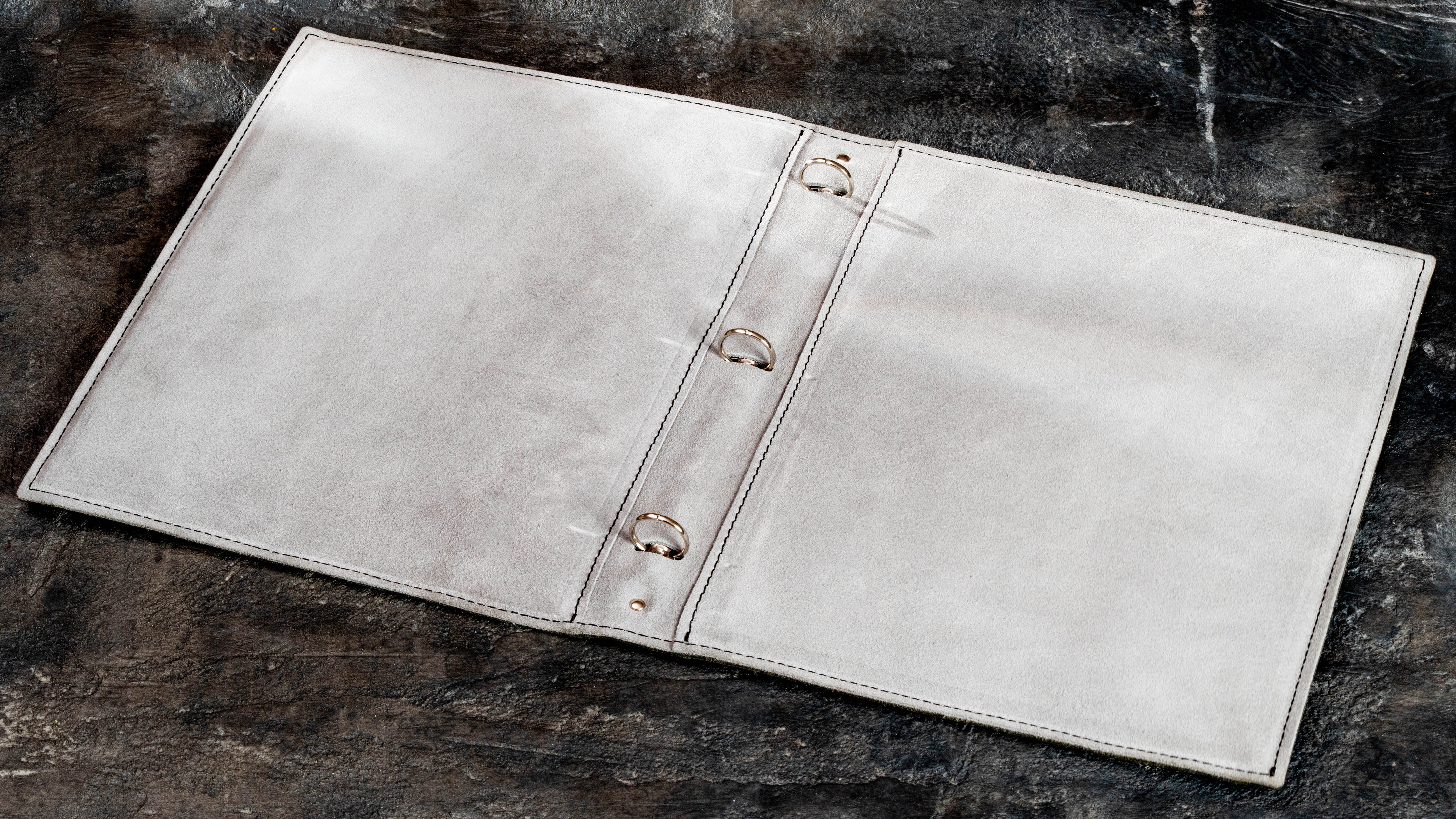 Light suede interior of travel memory binder with 25 mm three-ring mechanism for A4 and 8.5 × 11 pages.