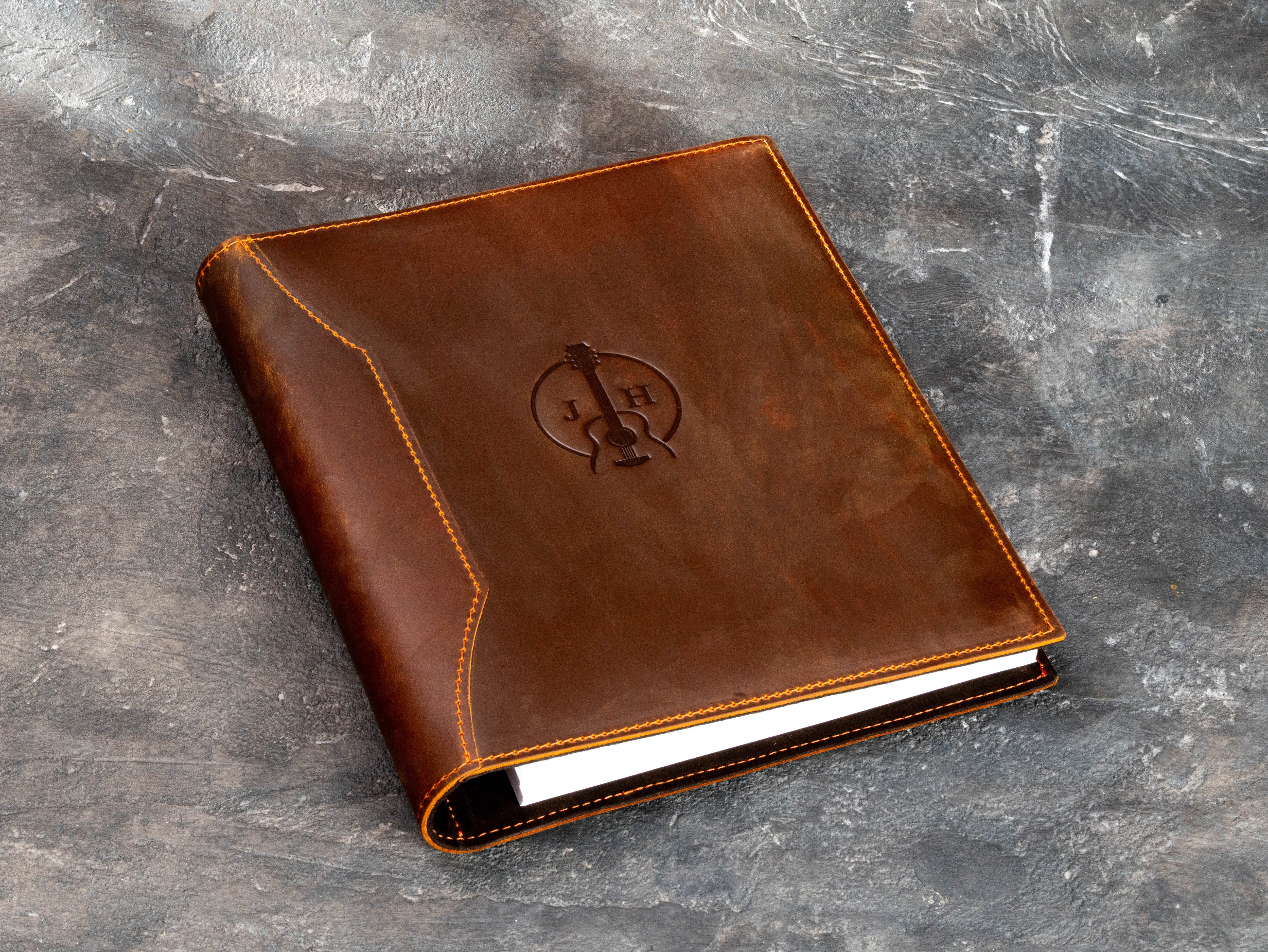 Personalized leather music binder with guitar emblem and 25 mm ring mechanism for sheet music, lyrics and memorabilia.