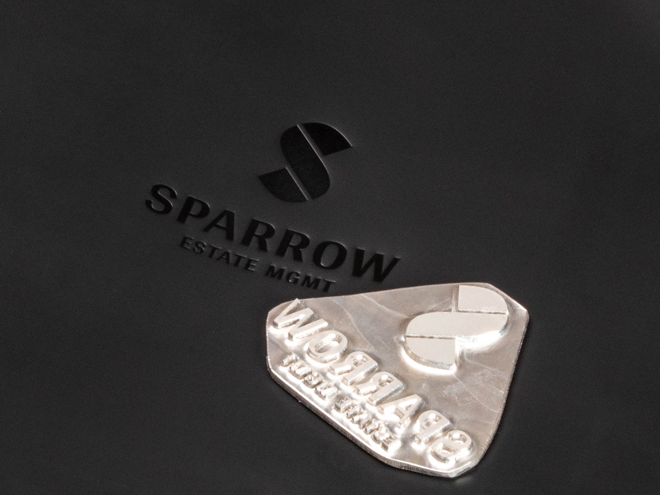 Close-up of custom embossed logo on black leather portfolio binder with client branding example
