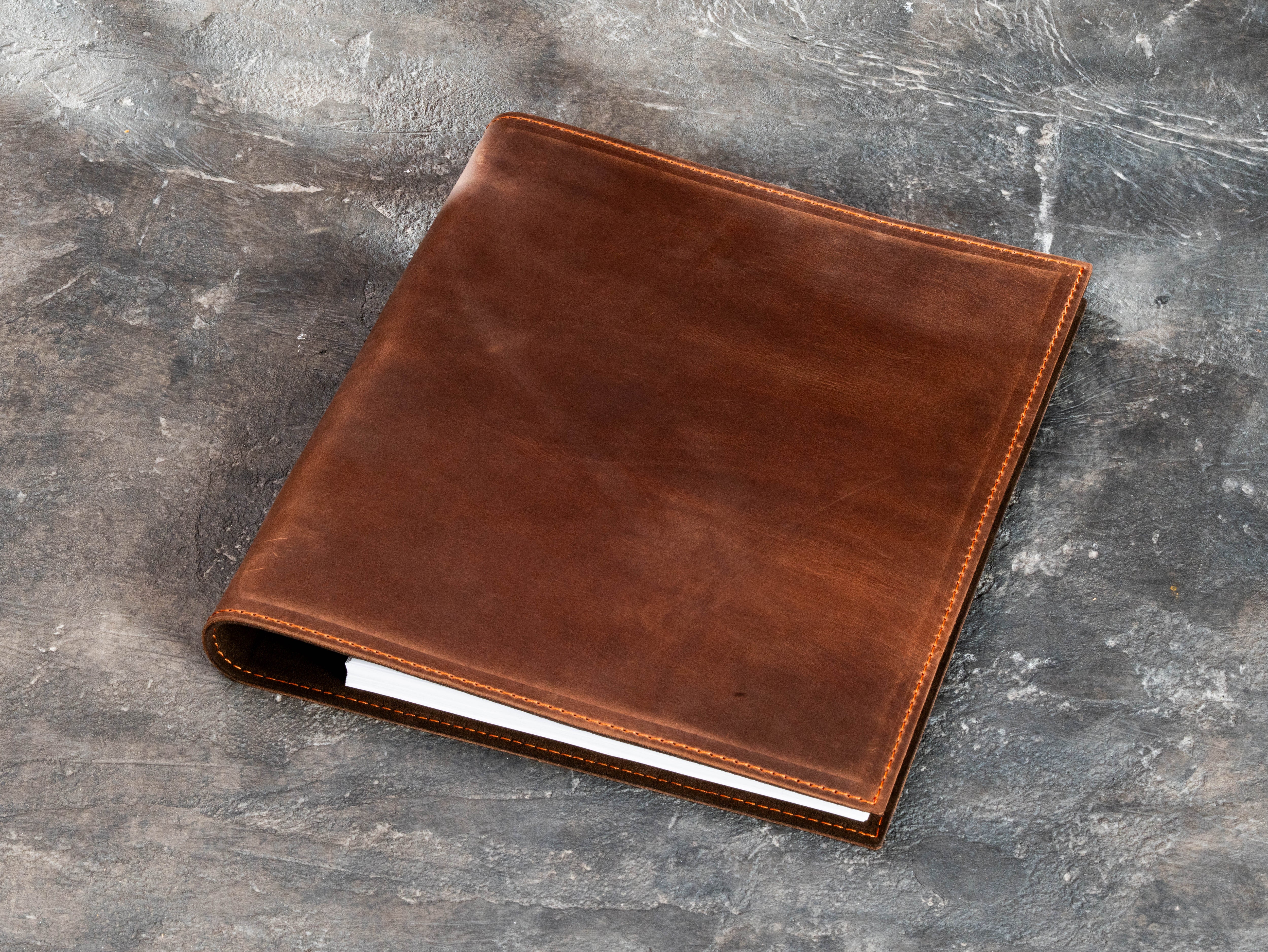 Back view of warm brown leather 3-ring binder showing natural leather texture and stitched construction