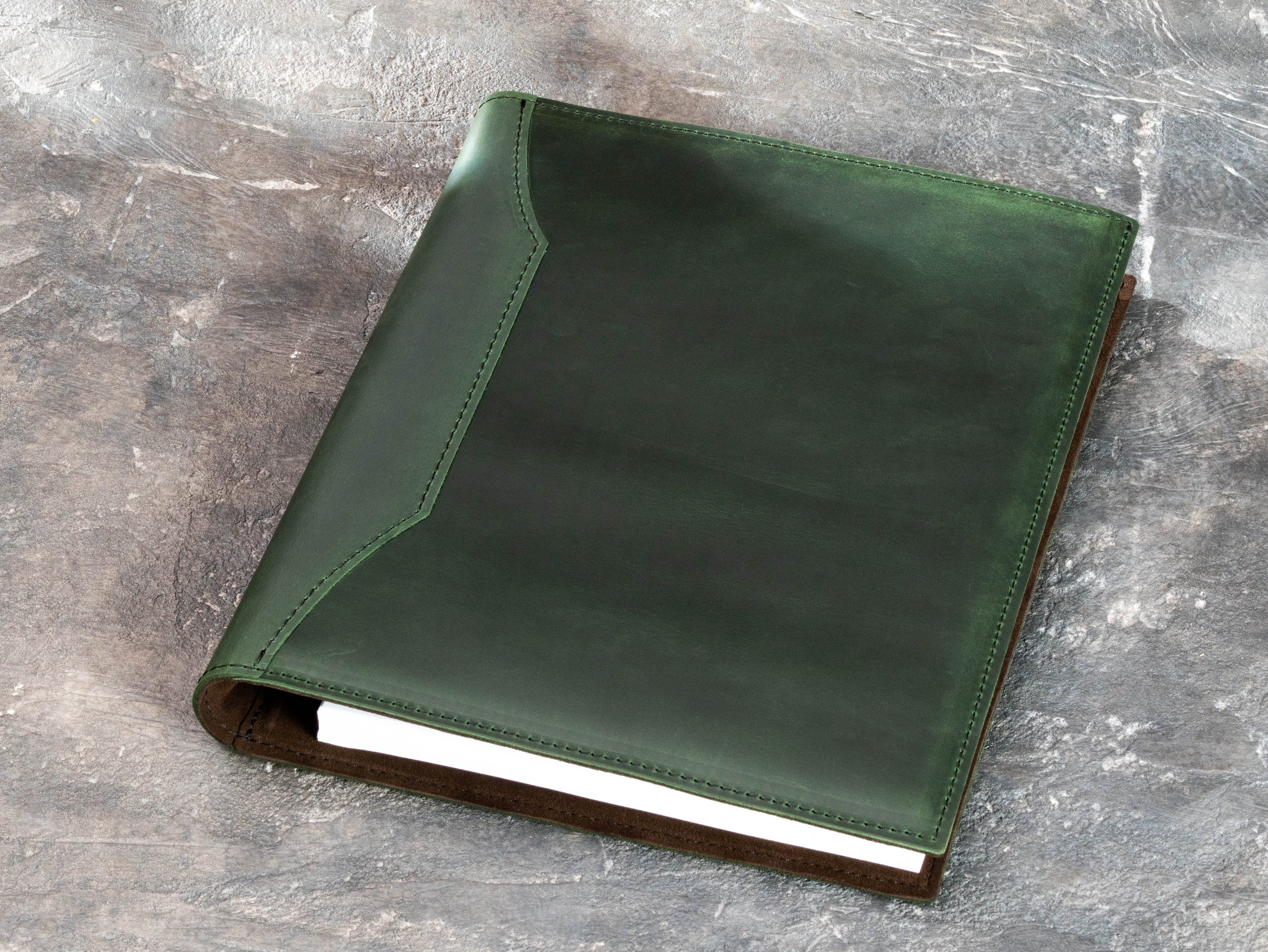 Back view of green leather memory binder showing natural leather texture and stitched construction
