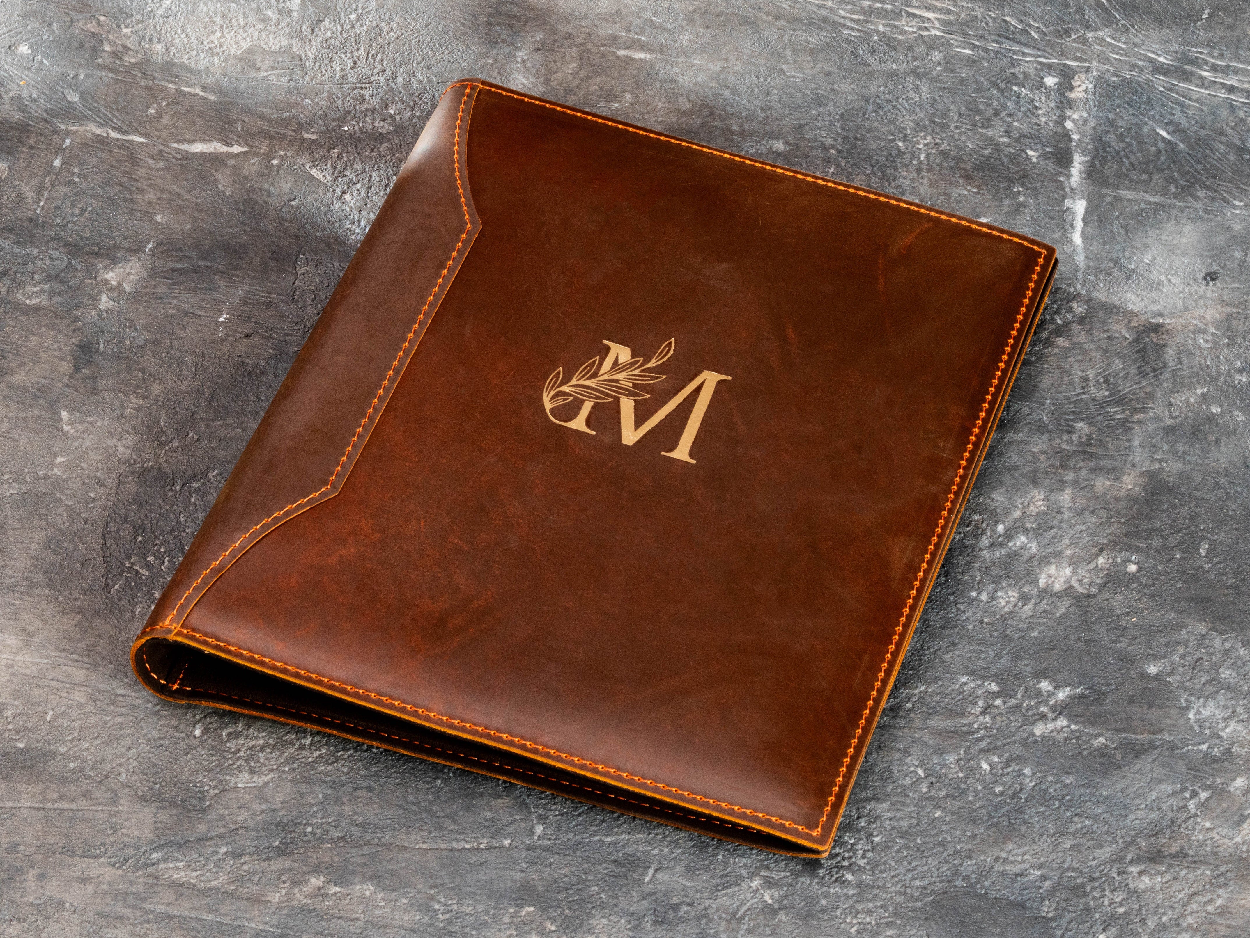 Chestnut brown leather keepsake binder with gold monogram personalization on the front cover