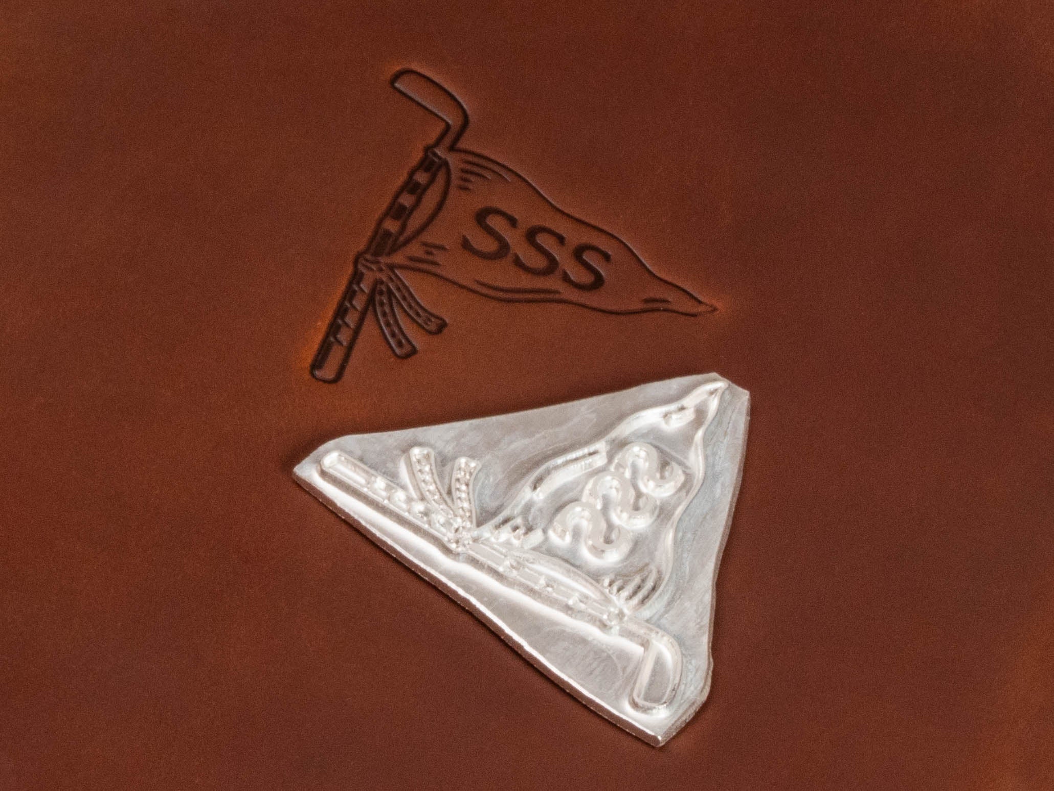 Close-up of custom golf logo embossing on leather with the embossing die used to create the design