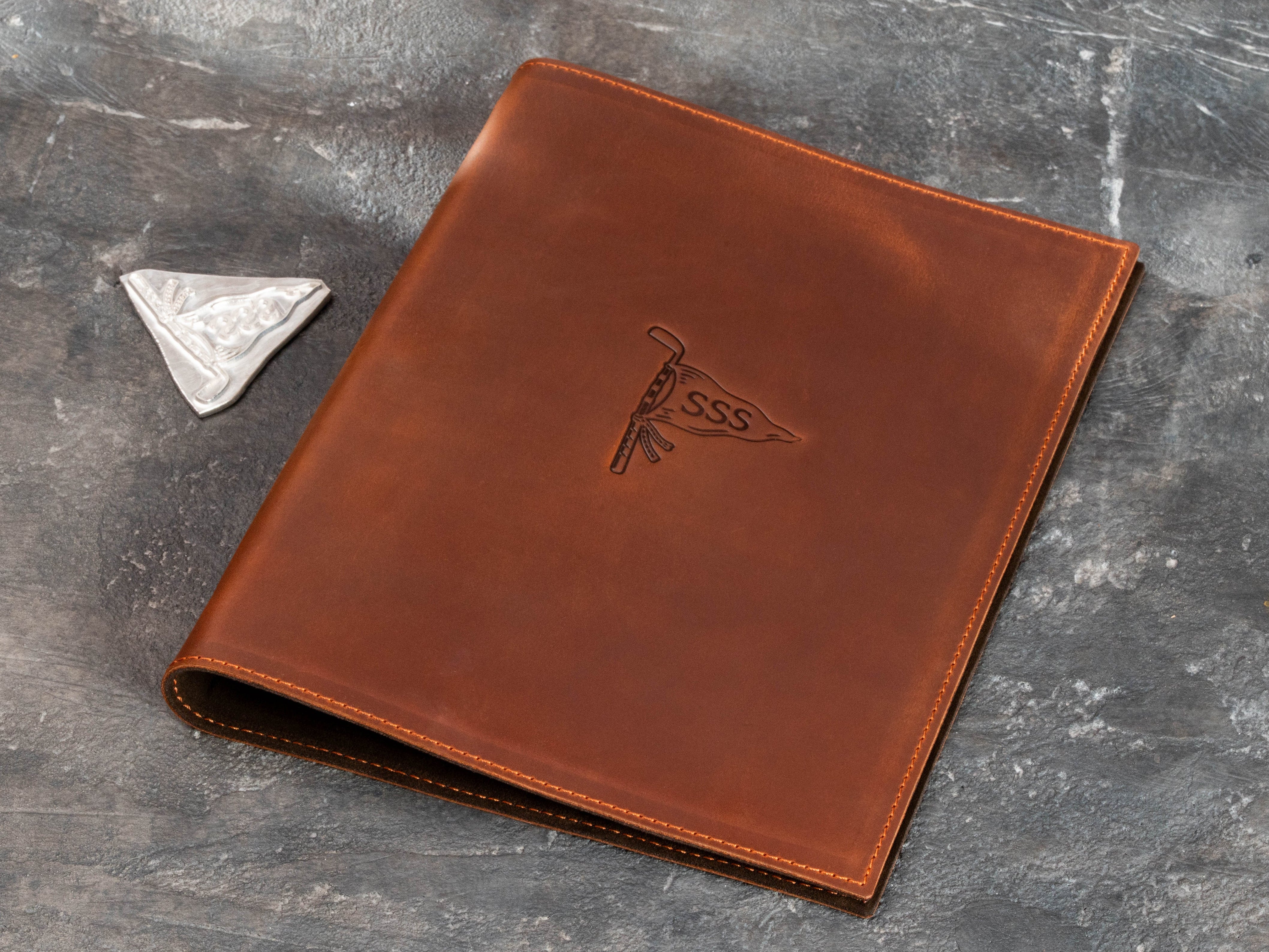 Personalized leather golf binder displayed with custom embossing die for golf logo personalization