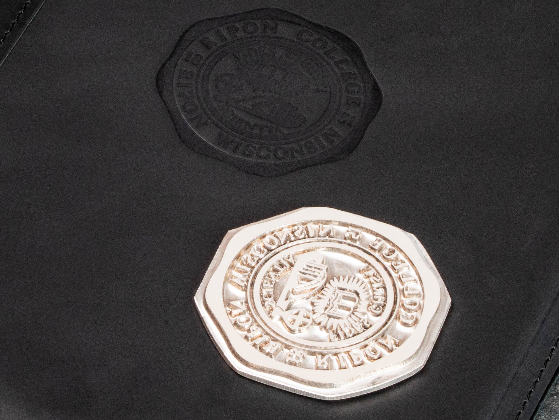 Personalized black leather college binder with subtle blind embossed emblem and structured cover design