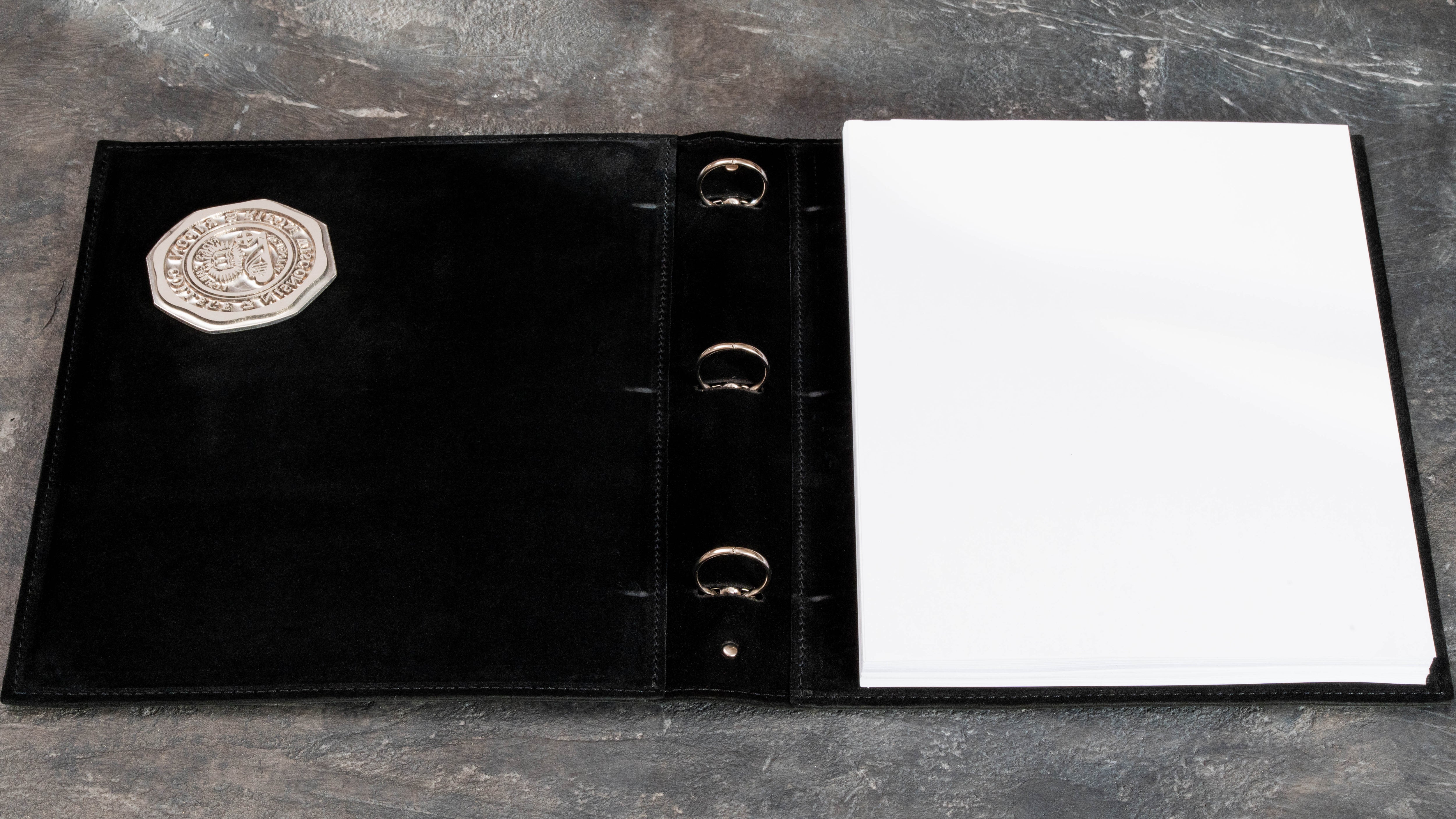 Black leather college memory binder with custom embossed school emblem and stitched edge construction