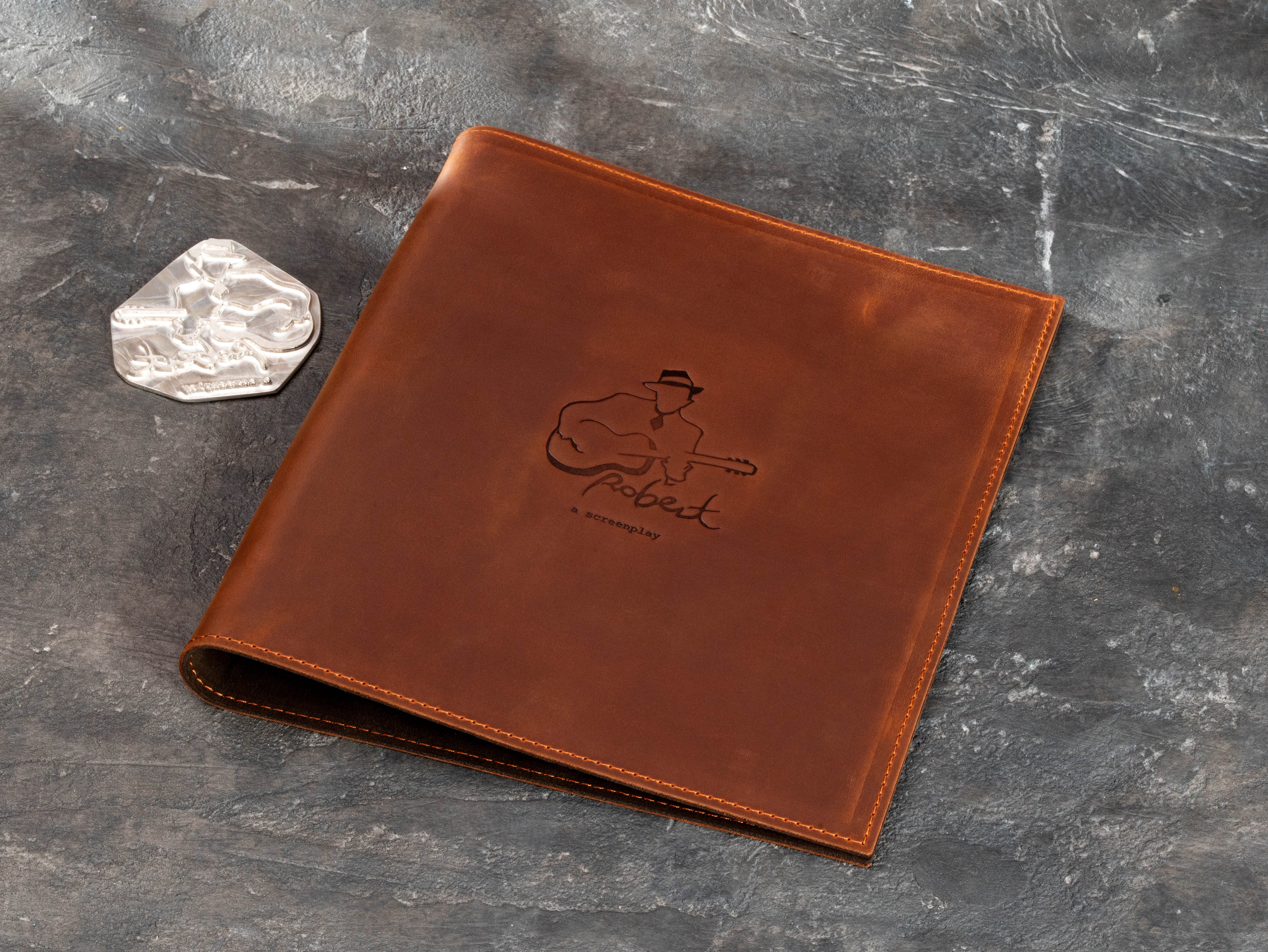 Personalized brown leather sheet music and screenplay binder for musicians with custom guitar embossing and matching embossing die.
