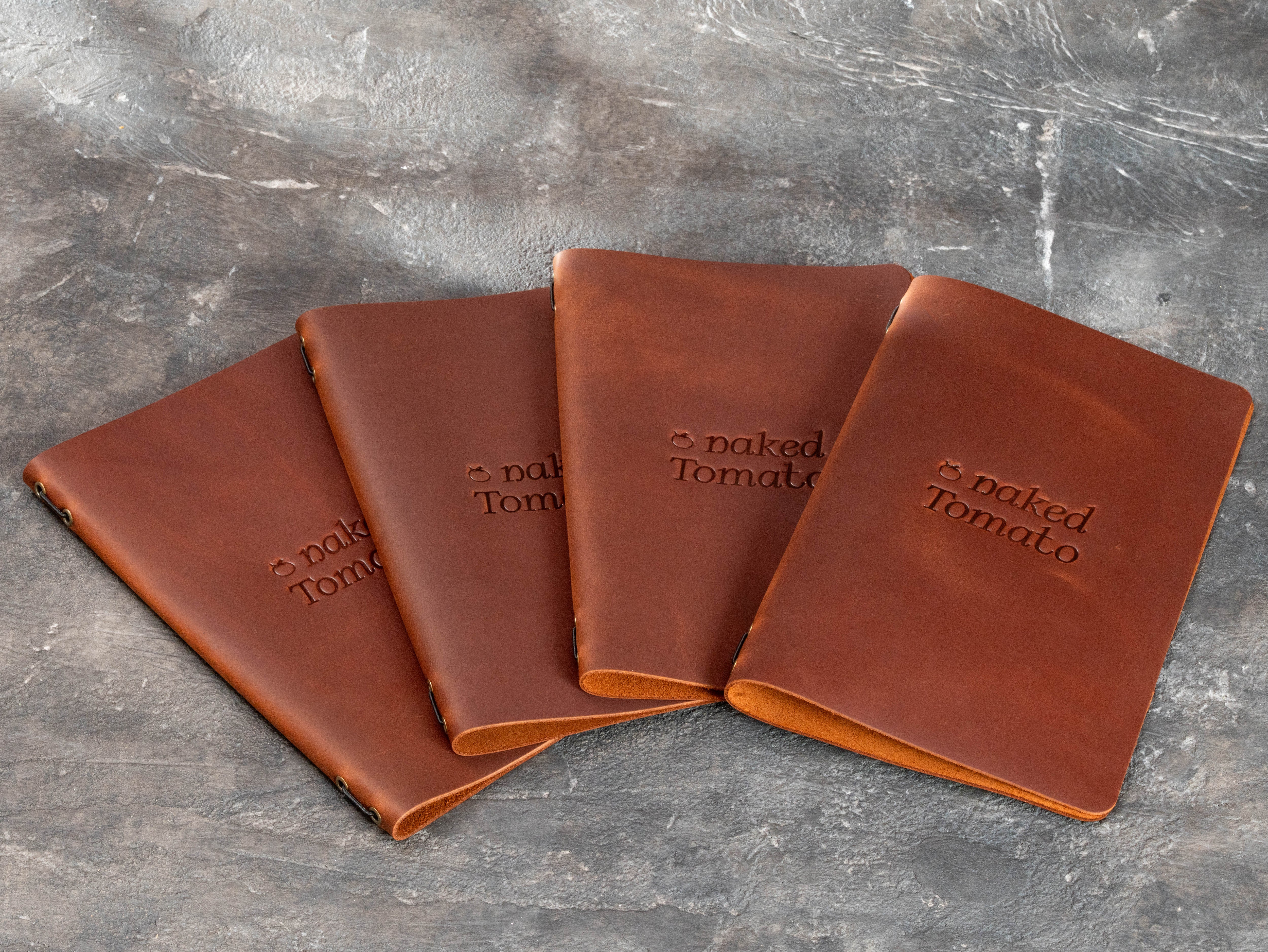 Set of branded brown leather menu books with Naked Tomato logo and flexible restaurant menu formats