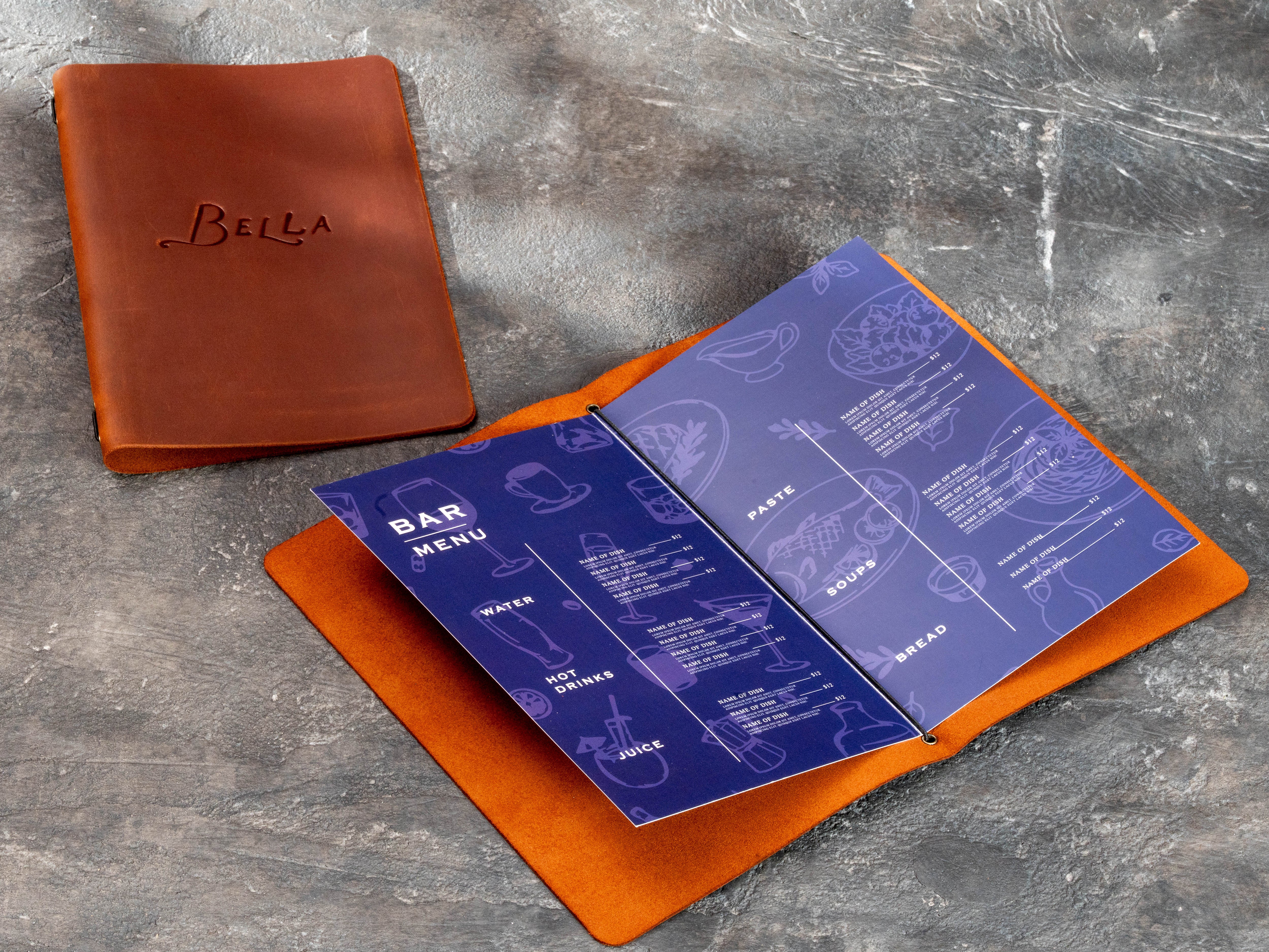 Custom Bella leather menu cover displayed beside an open restaurant menu with replaceable printed pages and elastic cord binding