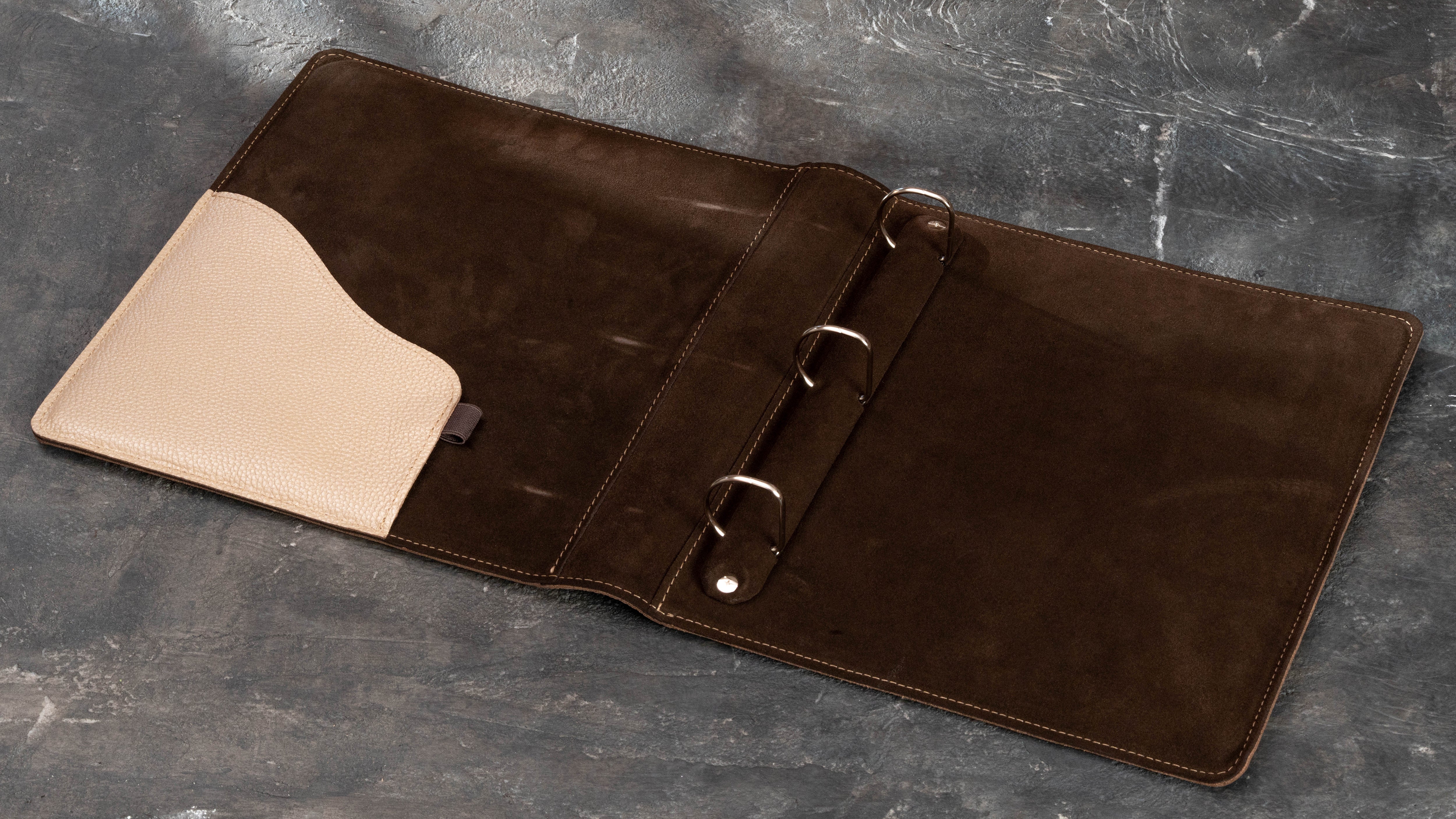 Open leather home archive binder with pen loop and gold pen inside