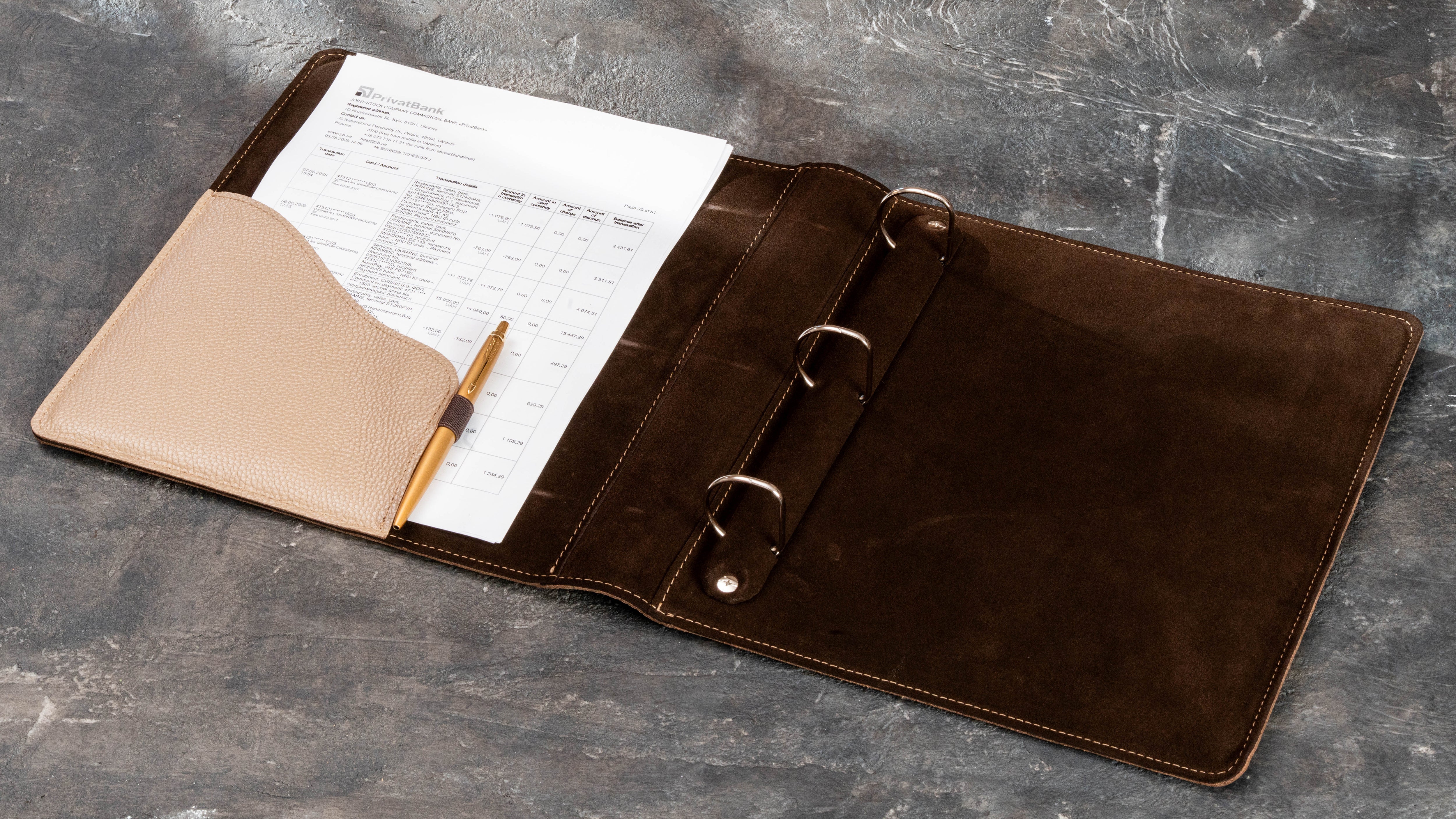Open leather binder with 1.6 inch D-rings, document pocket, and dark brown interior