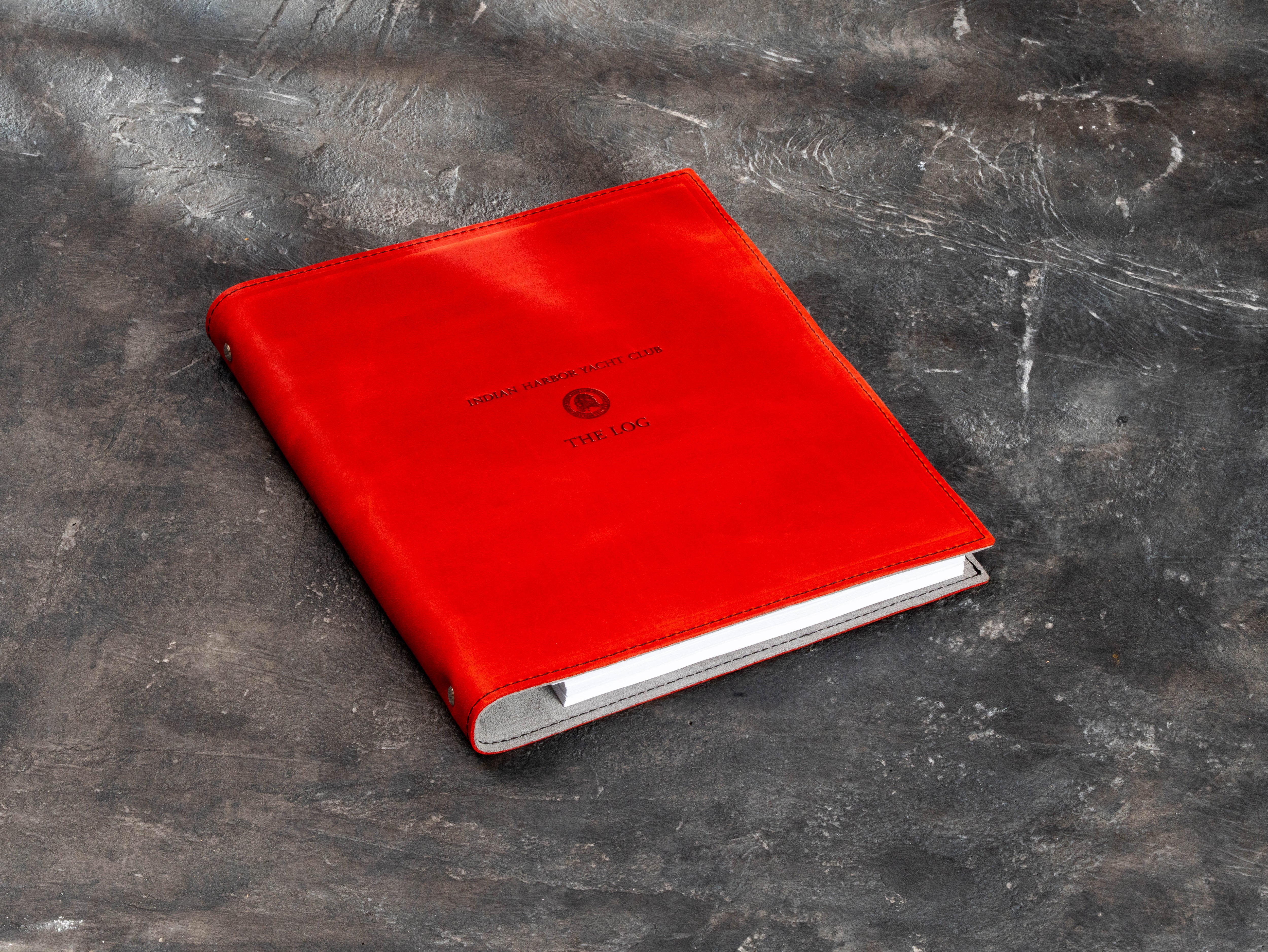 Angled view of custom red leather yacht club binder for member materials, sailing records and club archives.