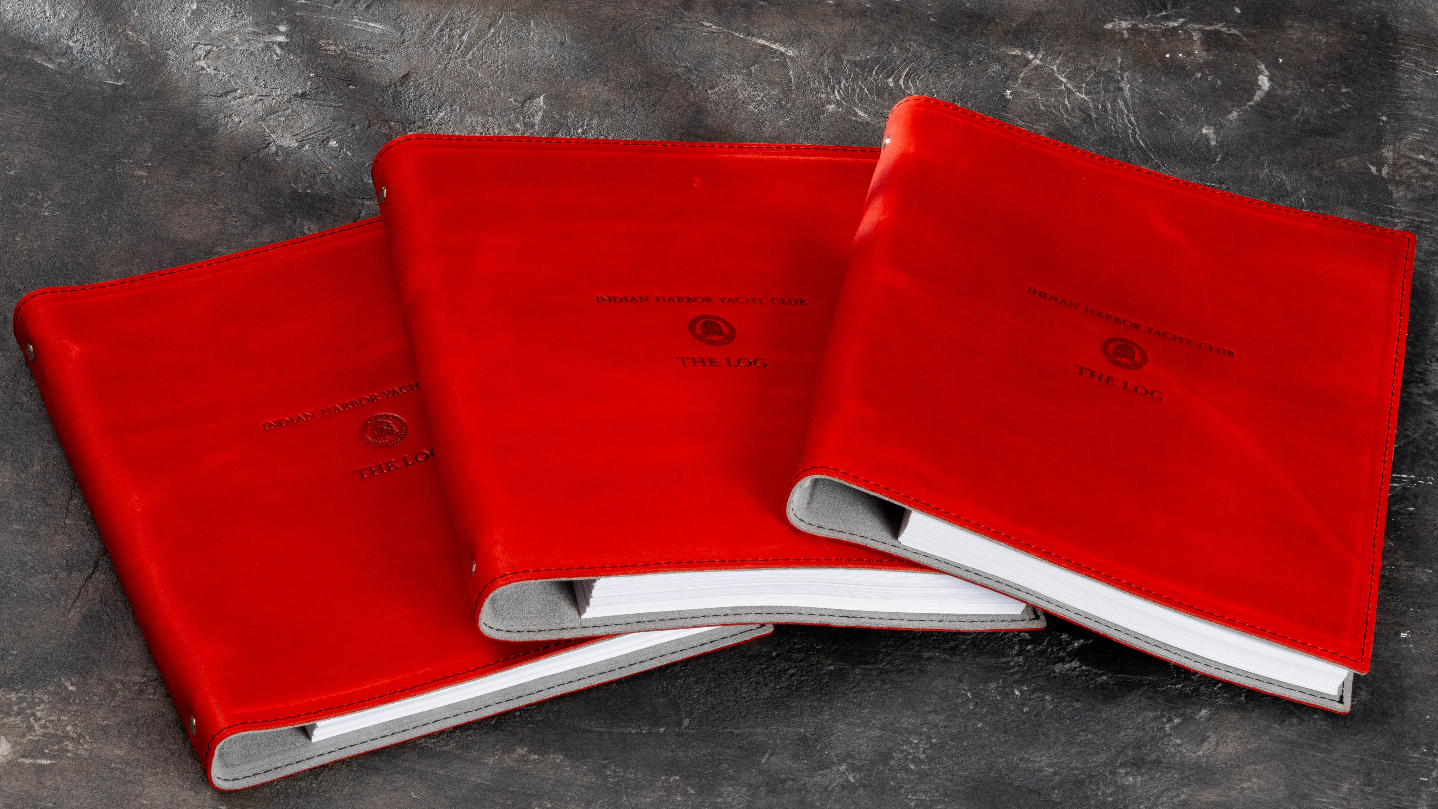 Series of three red leather yacht club member binders produced with matching custom crests and The Log titles.