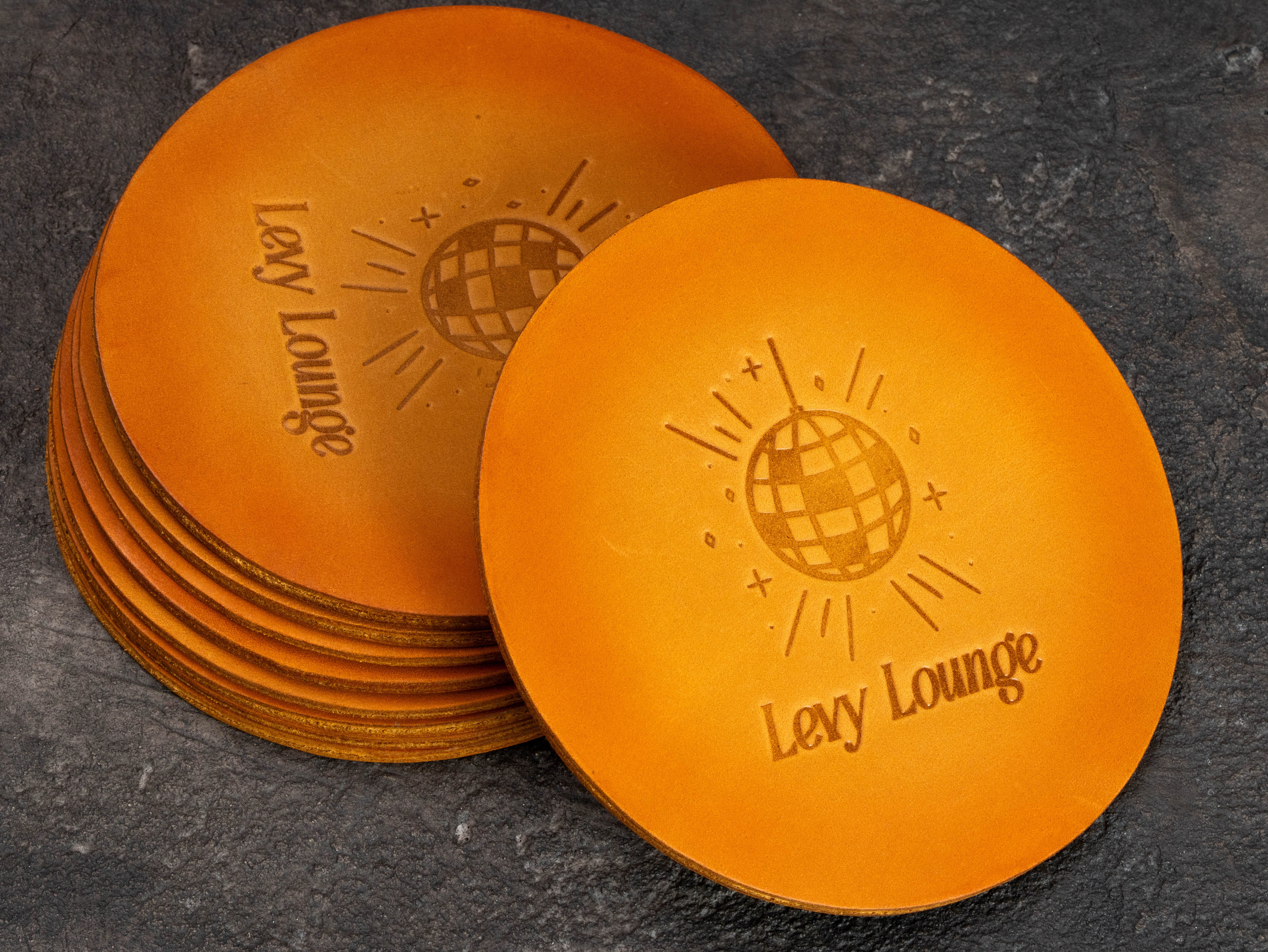 Custom leather coasters for a home bar or lounge with personalized disco ball design and hand-finished color