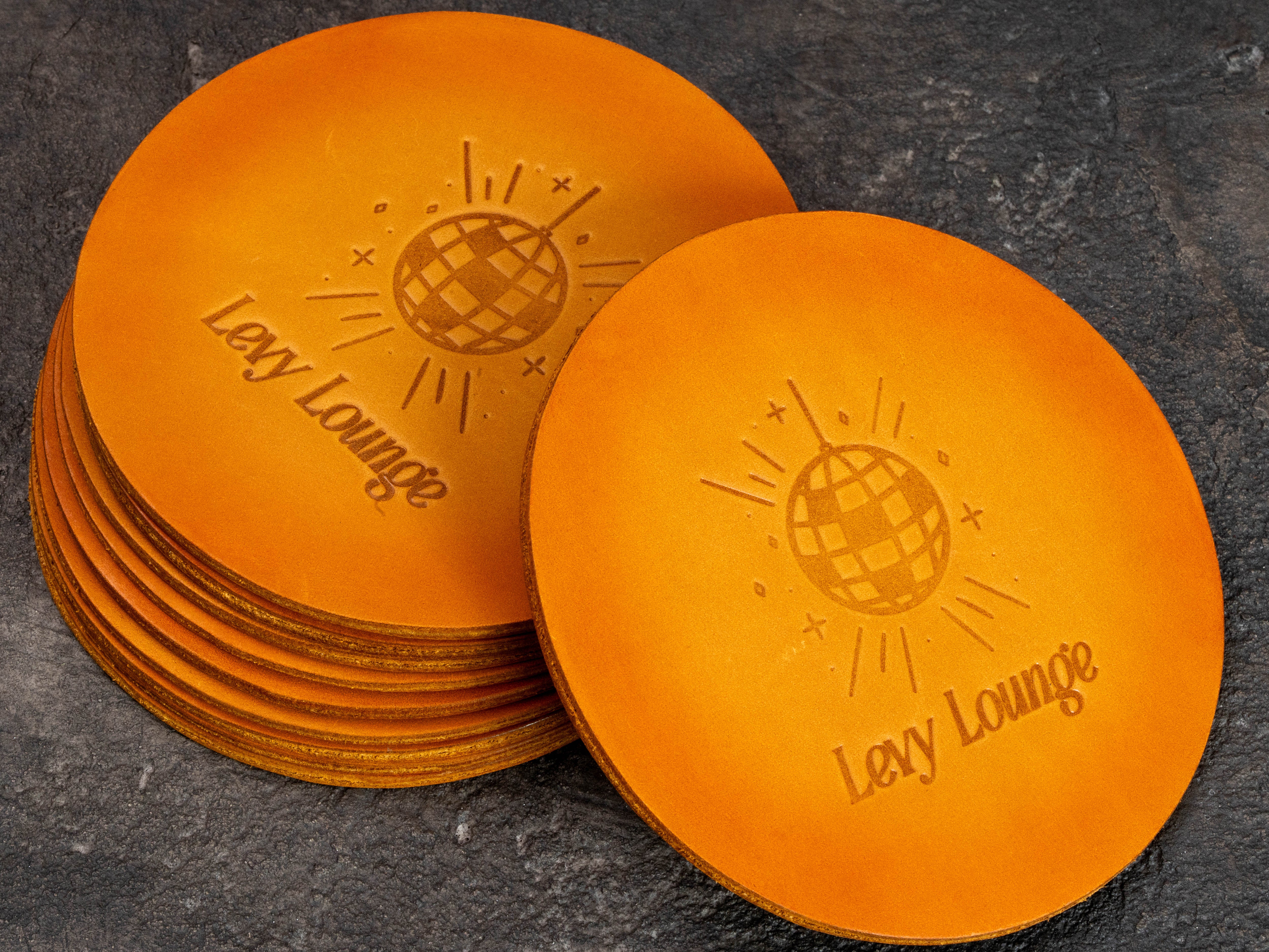 Set of hand-colored leather drink coasters with custom double-sided embossing for home bar and lounge decor
