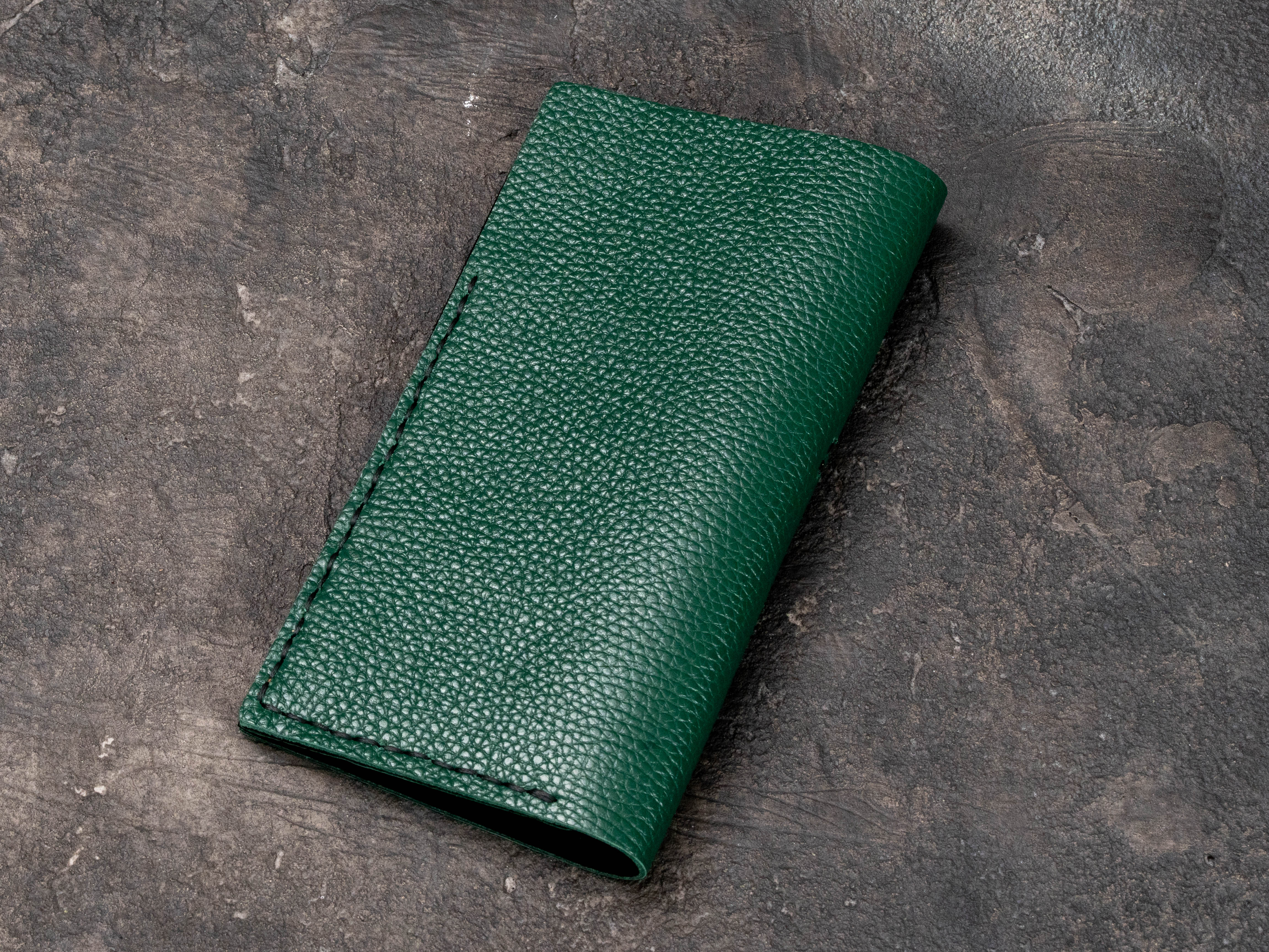 Back view of green floater leather restaurant check presenter with clean minimalist exterior