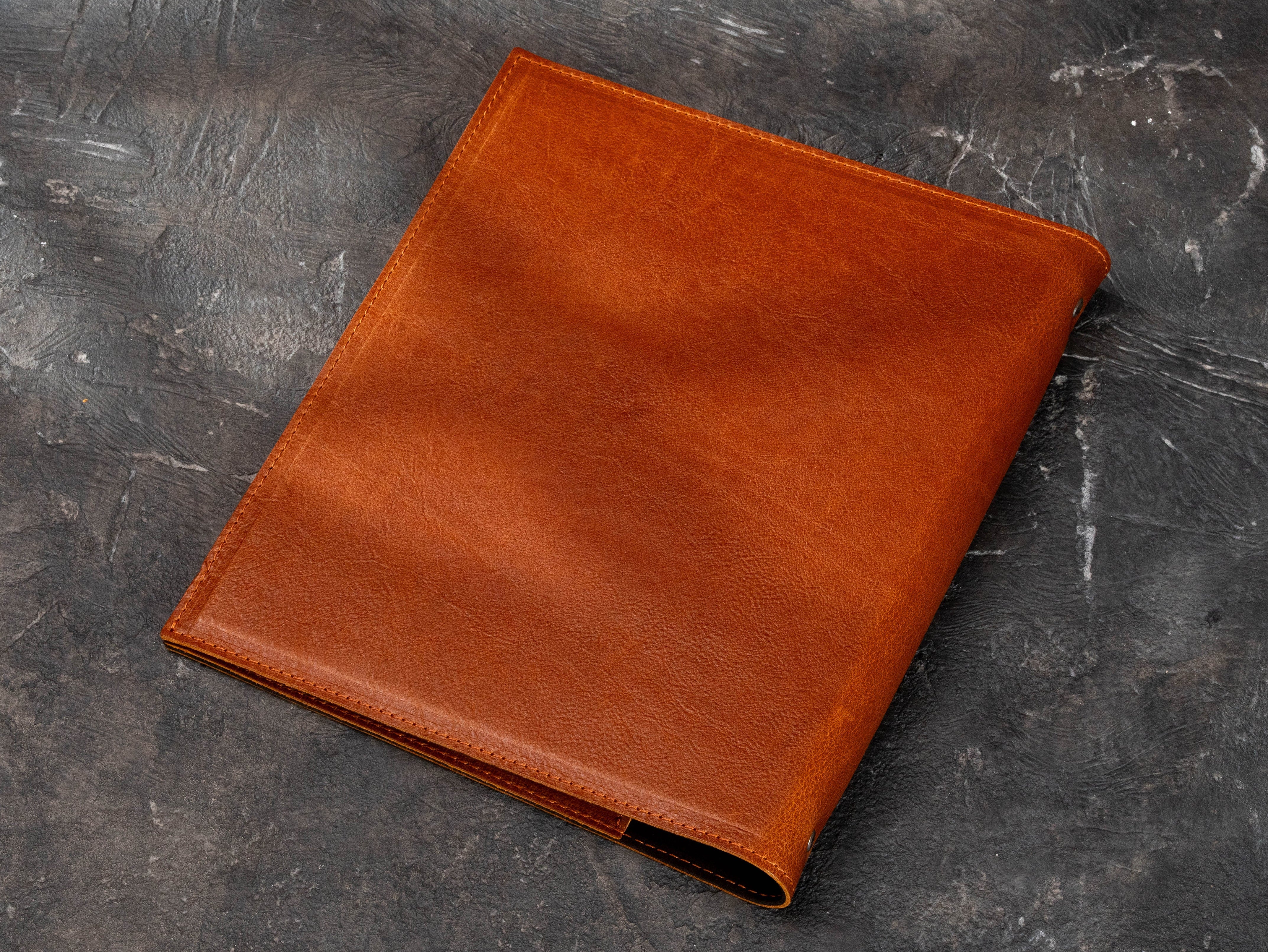 Back view of premium brown leather real estate binder with clean stitched edges and professional business finish.