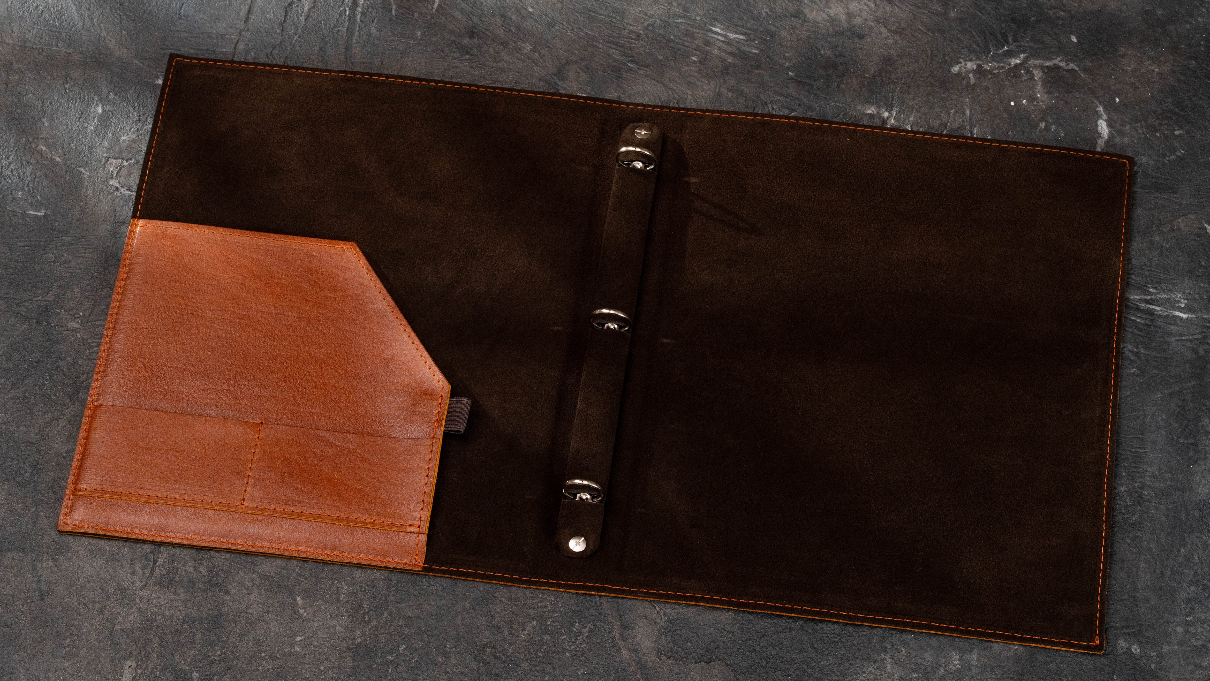 Open leather real estate binder with 3-ring mechanism, large interior document pocket, card slots and pen holder.