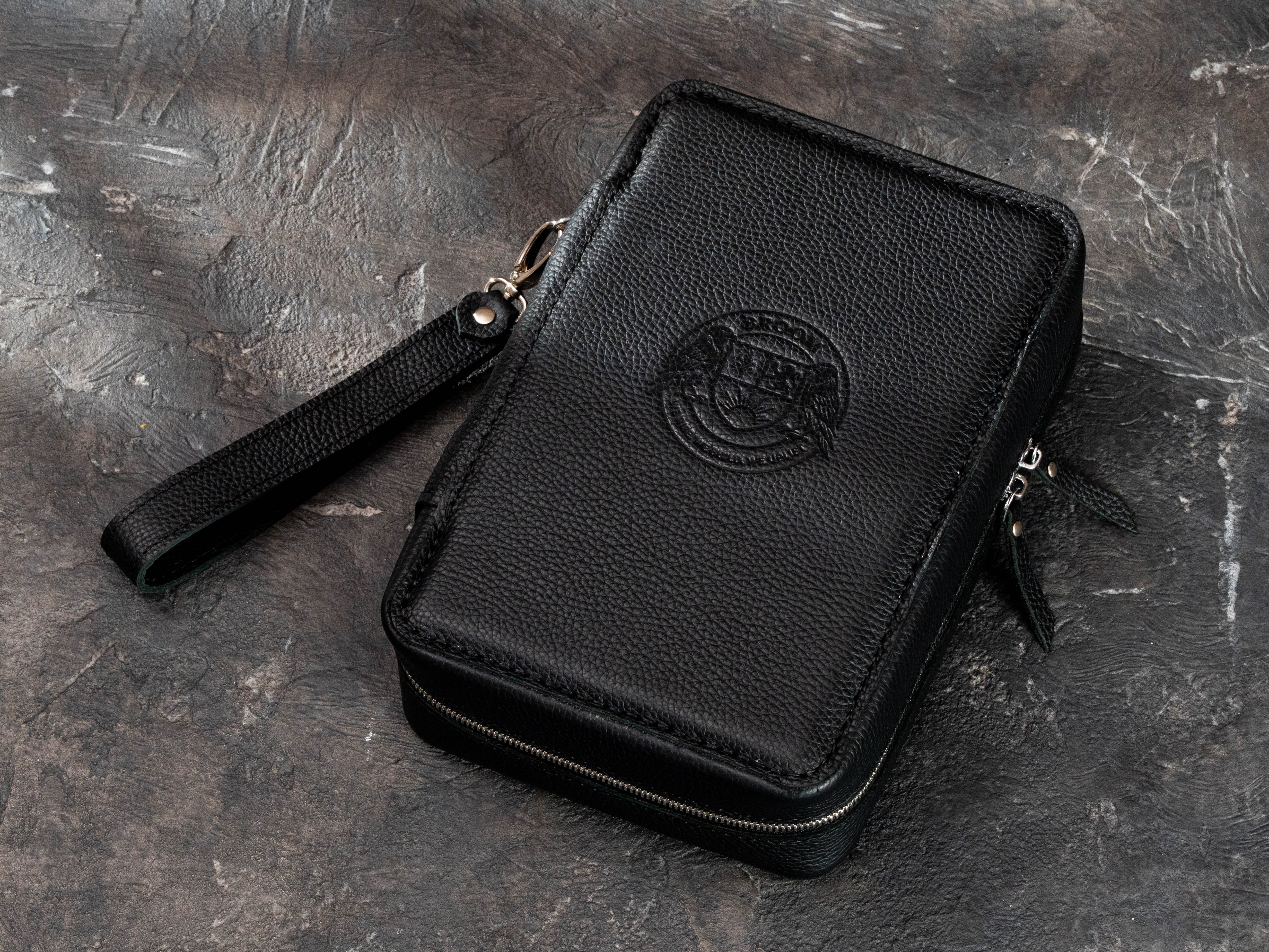 Black textured leather cigar club case with custom embossed logo, dual zipper closure and removable wrist strap.