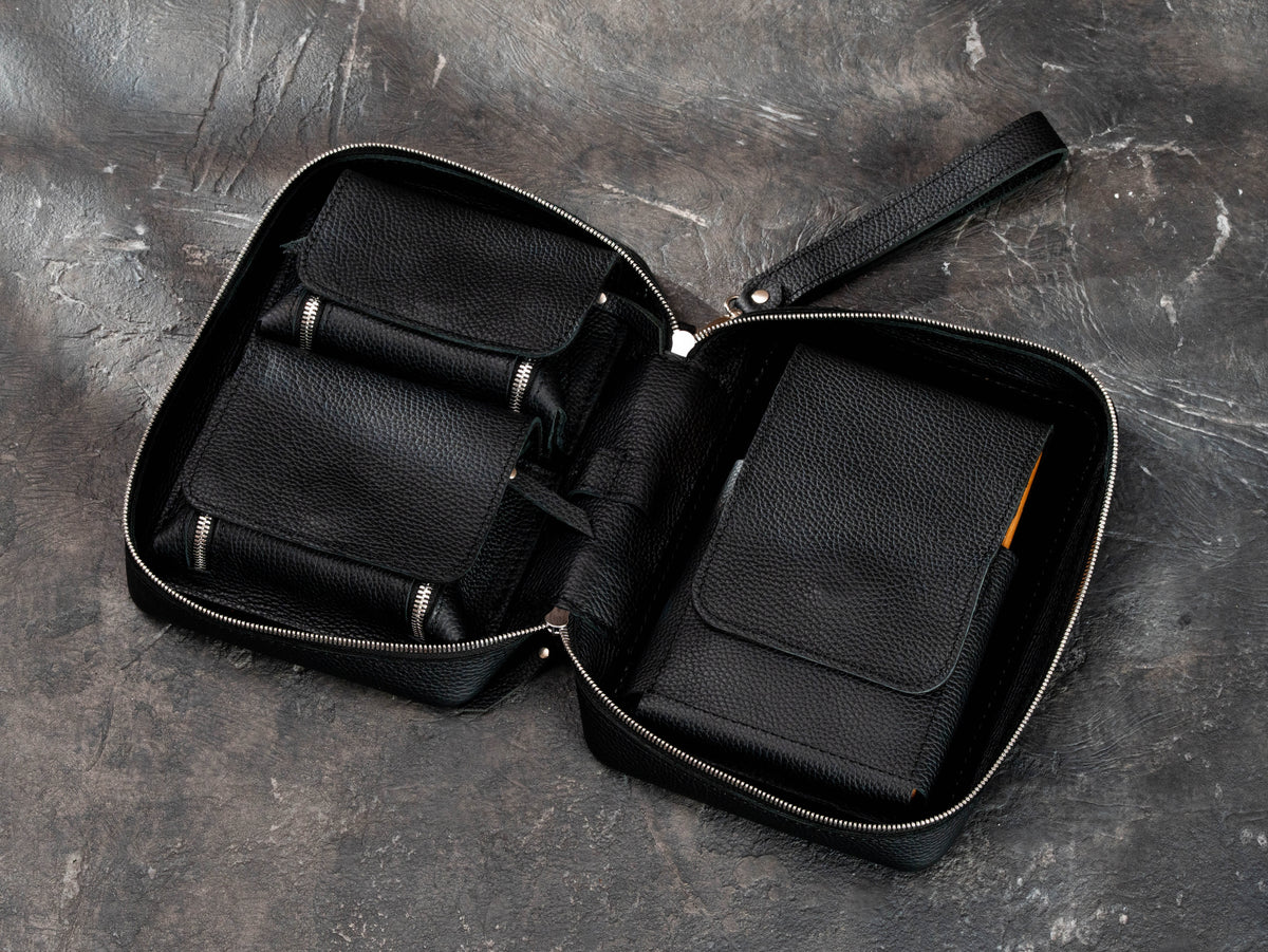 Open black leather cigar accessories case with magnetic compartments, removable oak cigar tray section and organized interior storage.