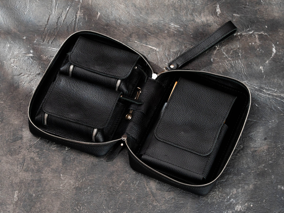Open black leather cigar case with two universal accessory compartments, magnetic closures and dedicated cigar storage section.