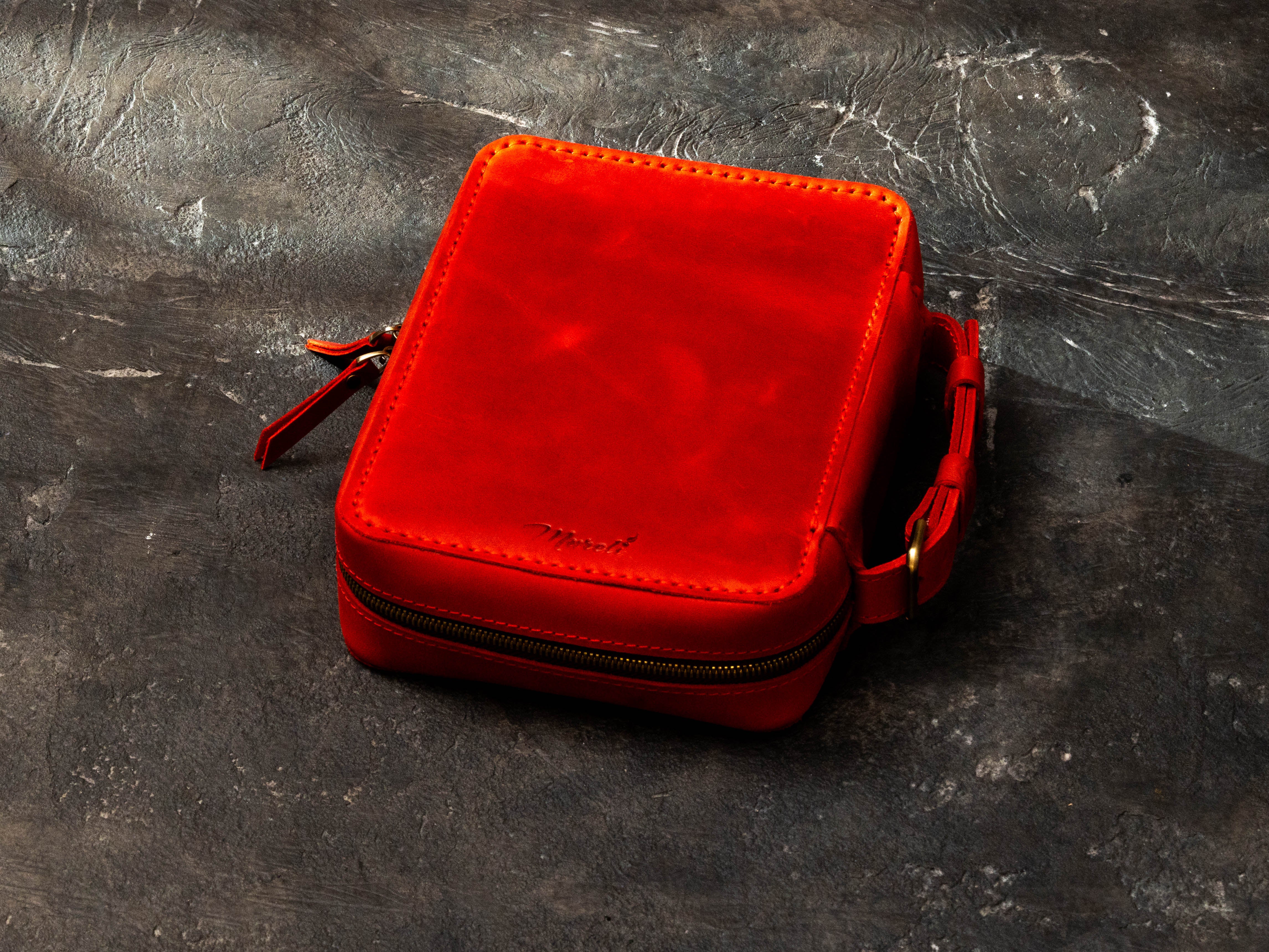 Back view of red leather Secret Brotherhood cigar case with stitched cover, side carrying handle and dual zipper design.
