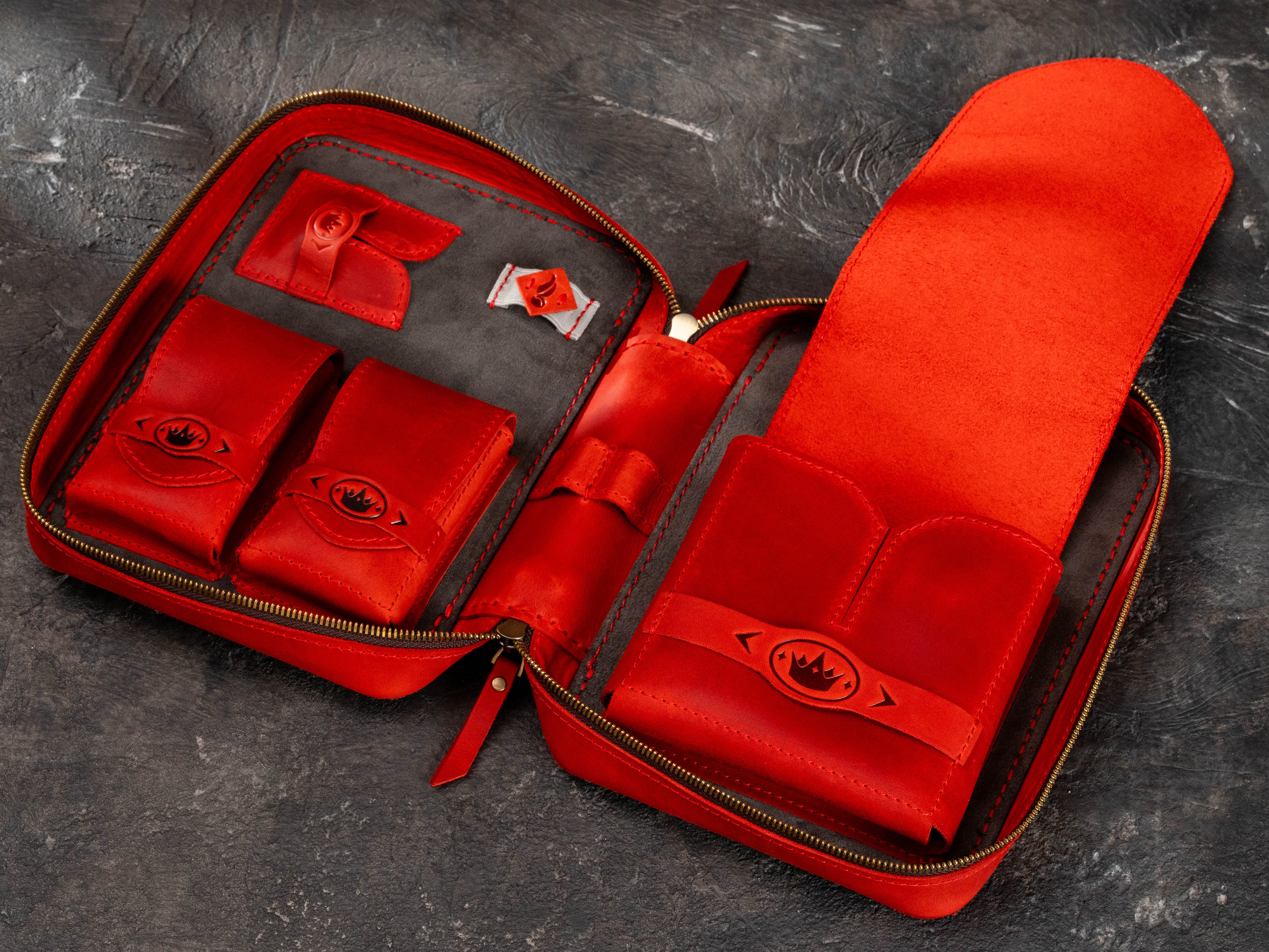 Open red leather cigar accessory case with large cigar compartment, multiple small organizer pockets and dark suede interior.