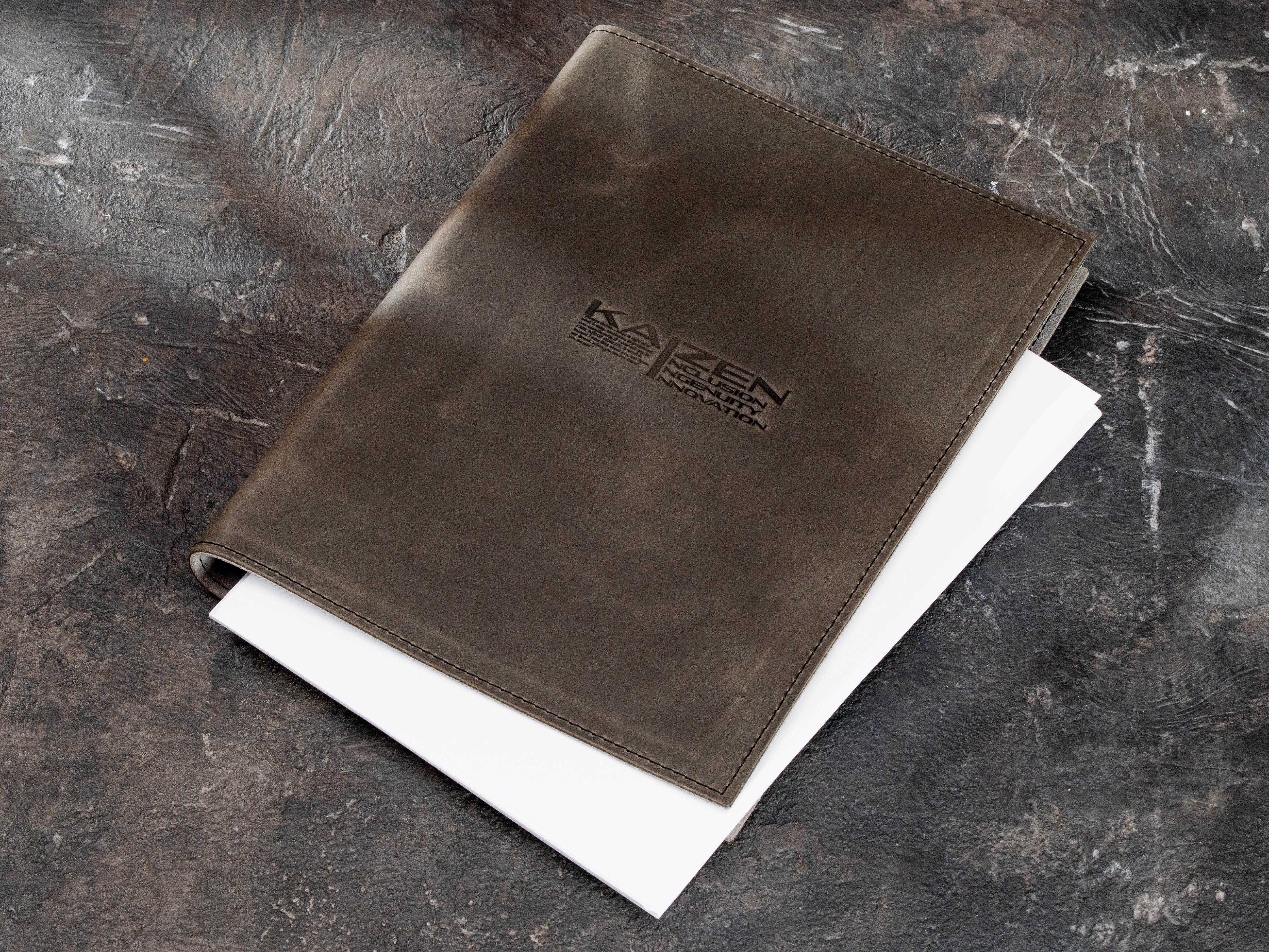 Gray leather business binder with custom corporate logo shown with document pages inside.