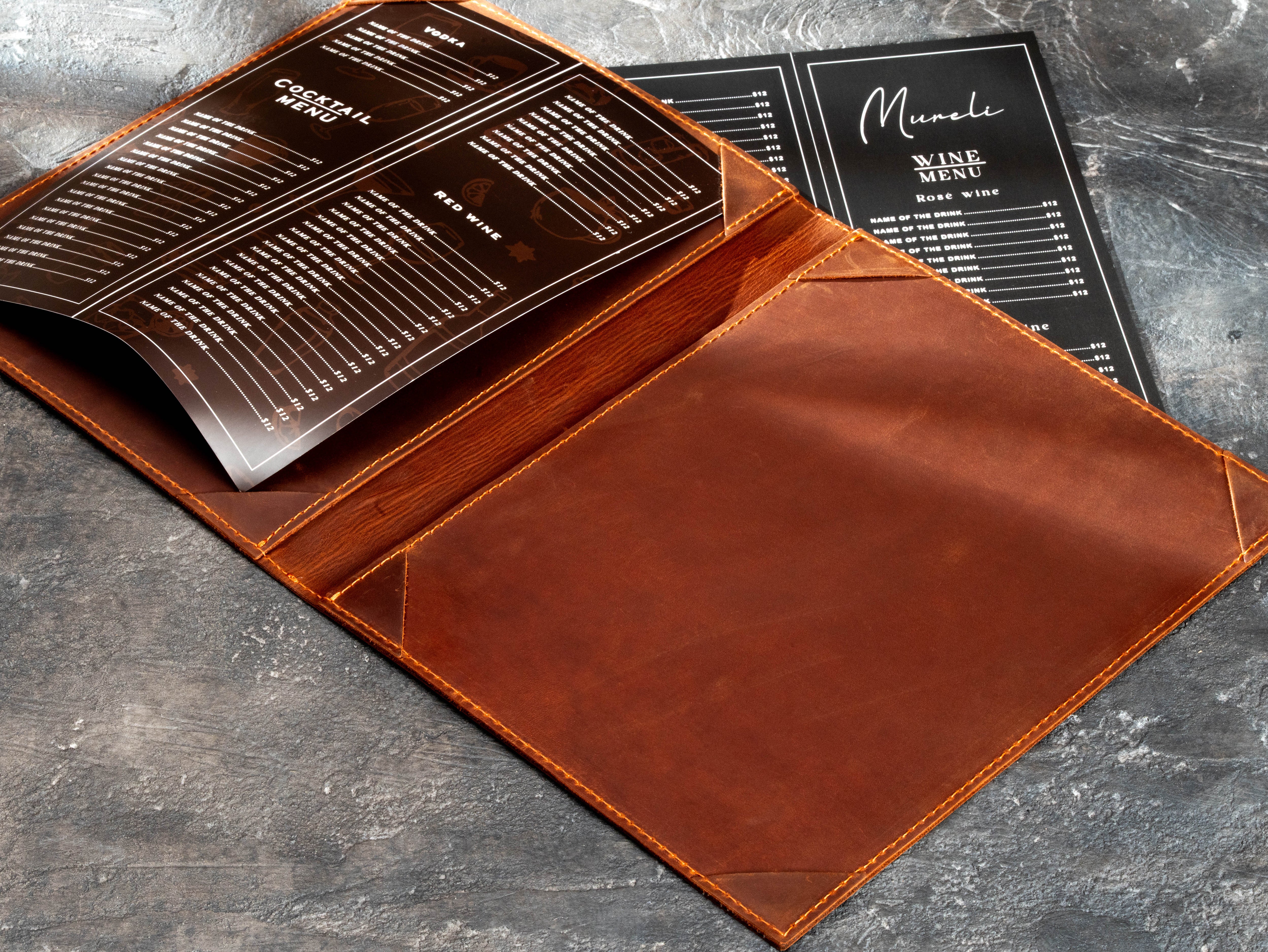 Restaurant menu folder with one printed menu sheet partially inserted under the leather corner holders.