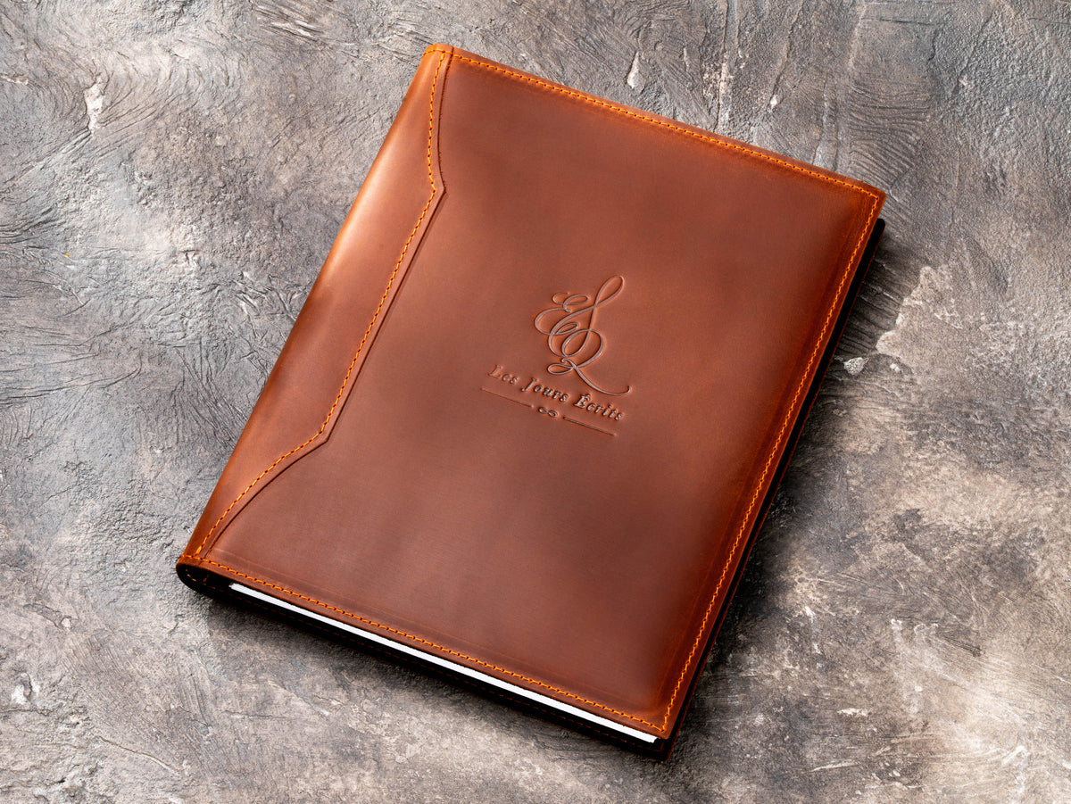 Custom copper leather presentation binder with embossed Les Jours Ecrits logo and stitched cover