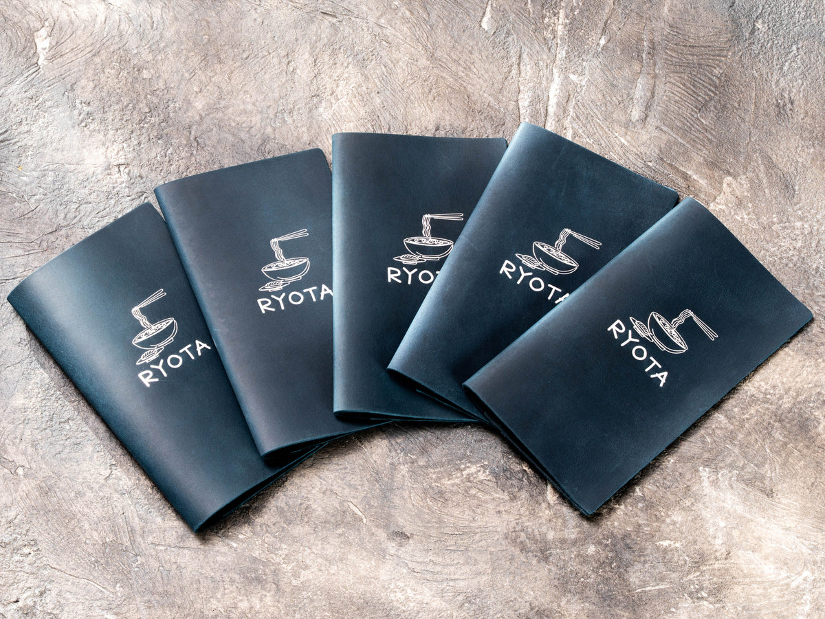 Custom navy blue leather check presenters with silver foil RYOTA restaurant logo