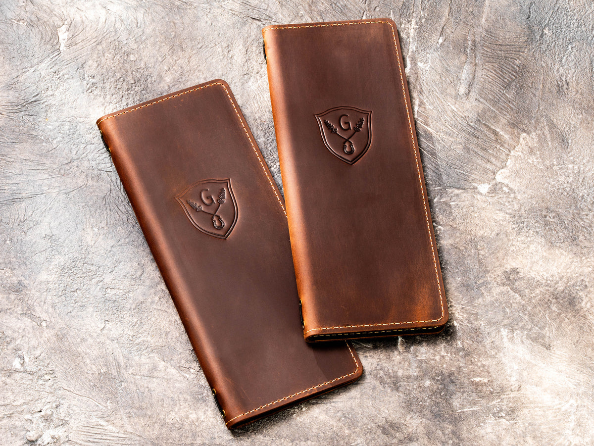 Custom brown leather cocktail menu covers with blind embossed crest logo and stitched edges