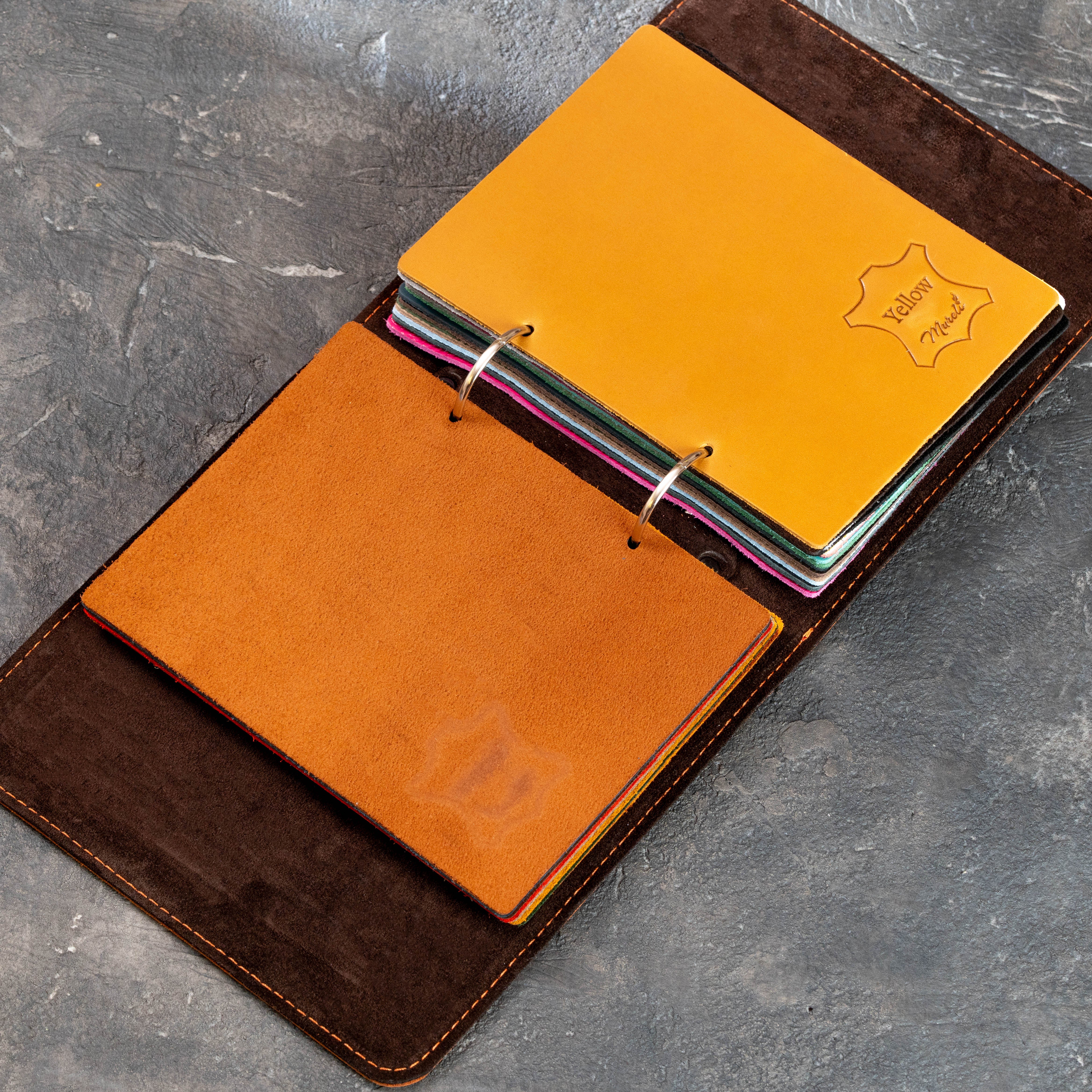 Open dark brown leather sample binder with gray, brown, and multicolor leather swatches for custom orders