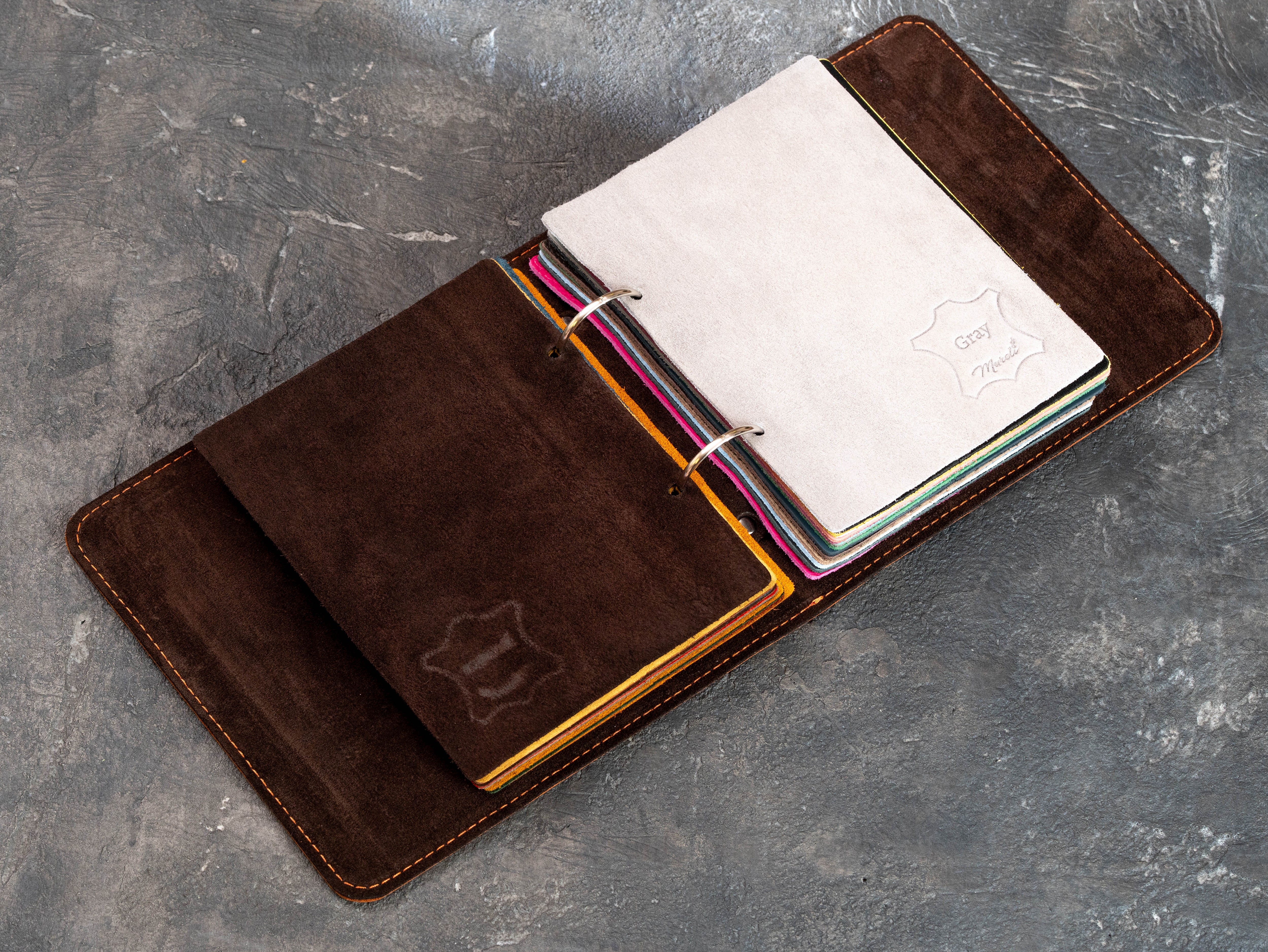 Leather sample folder with colorful turquoise, pink, yellow, and neutral leather swatches