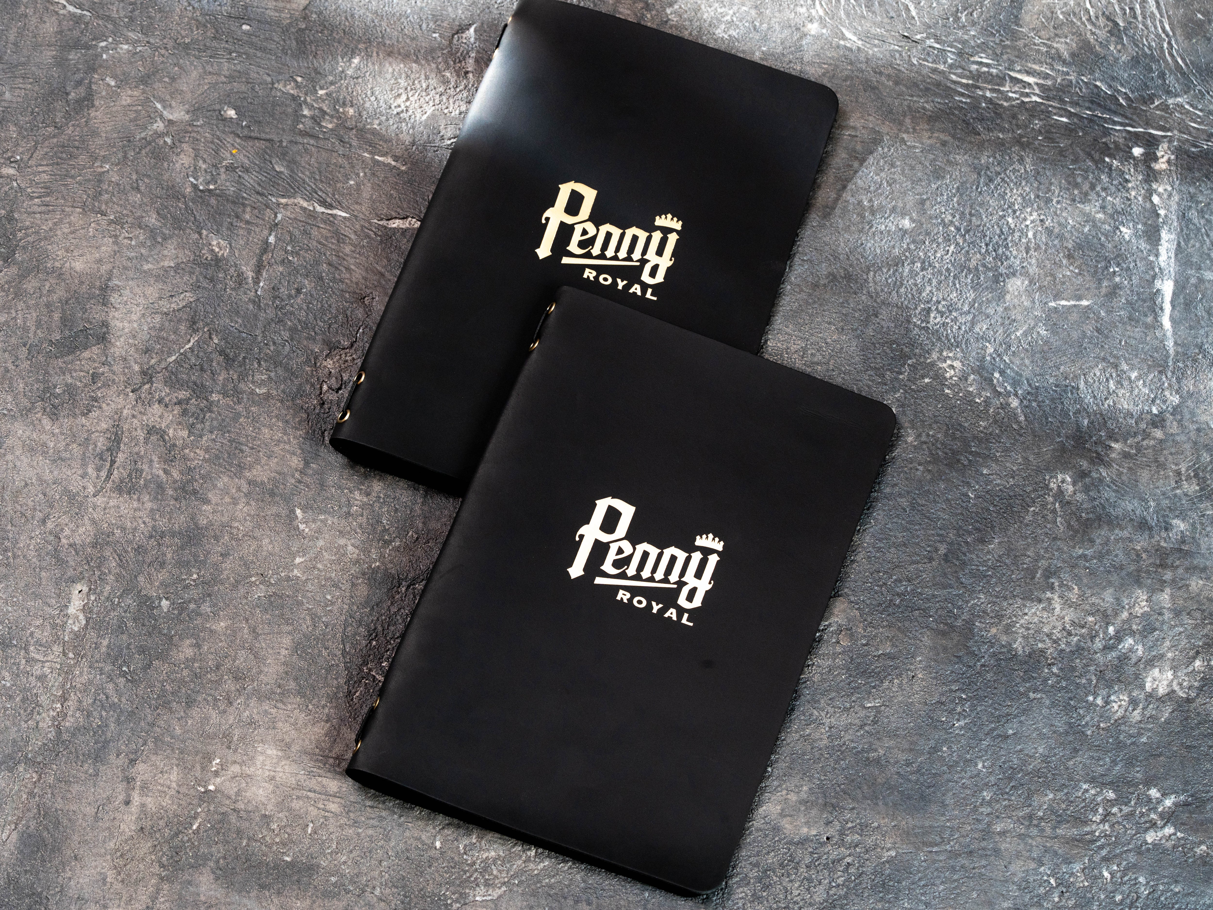 Inside view of black leather restaurant menu cover with suede interior, metal eyelets, and elastic binding