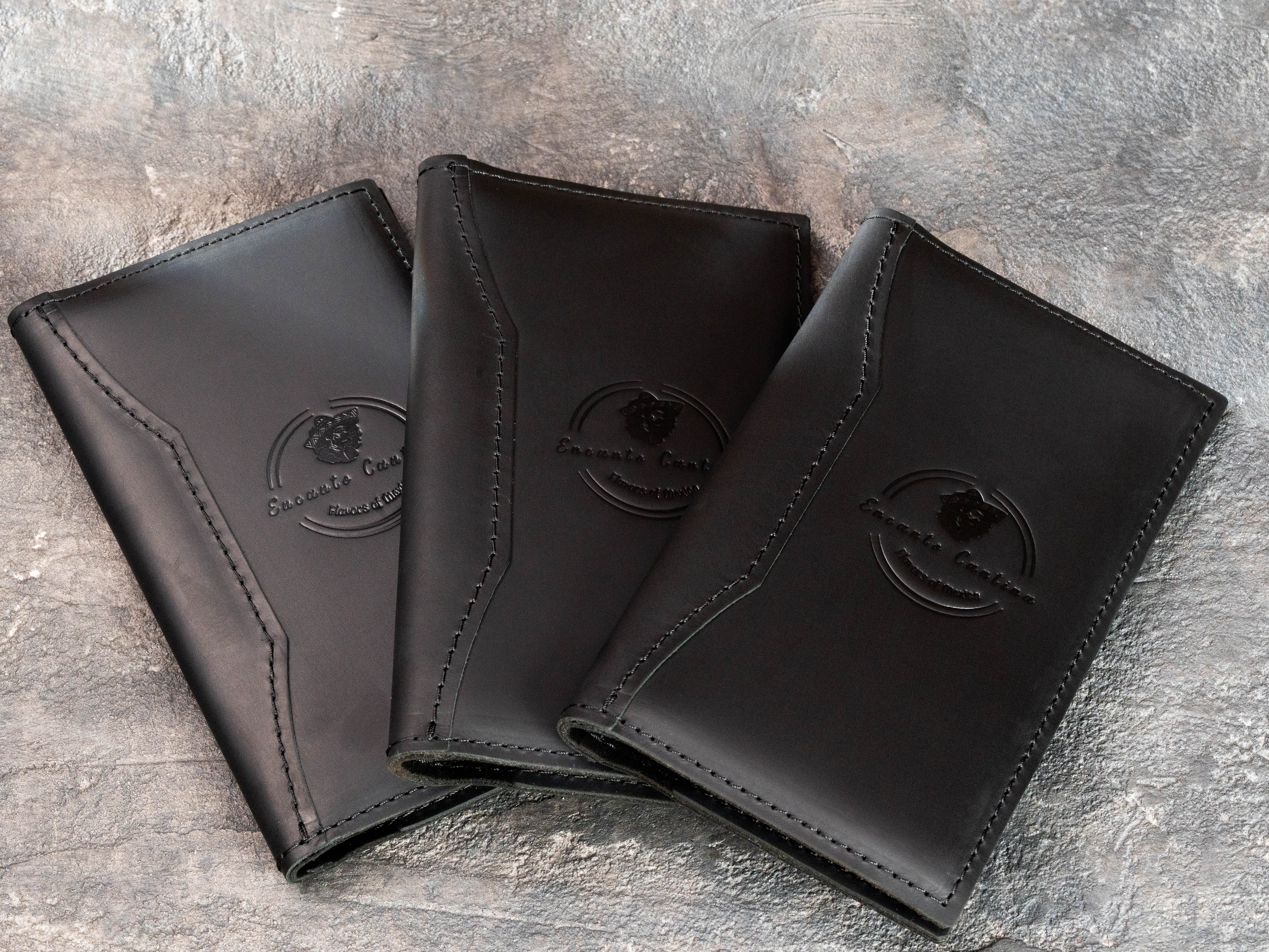 Set of black leather cantina bill holders with custom restaurant branding