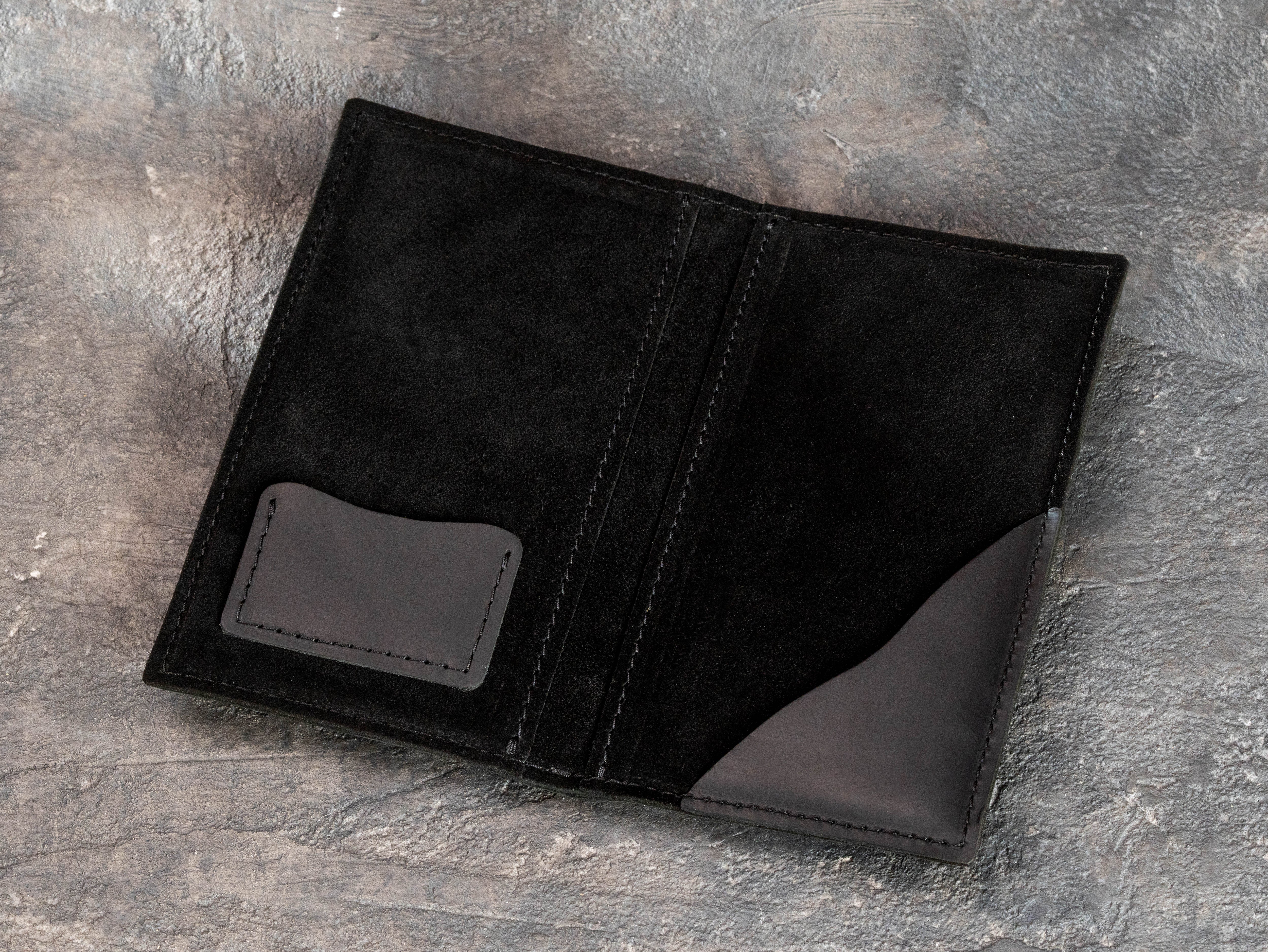 Open black leather restaurant bill holder with black suede interior and two functional pockets
