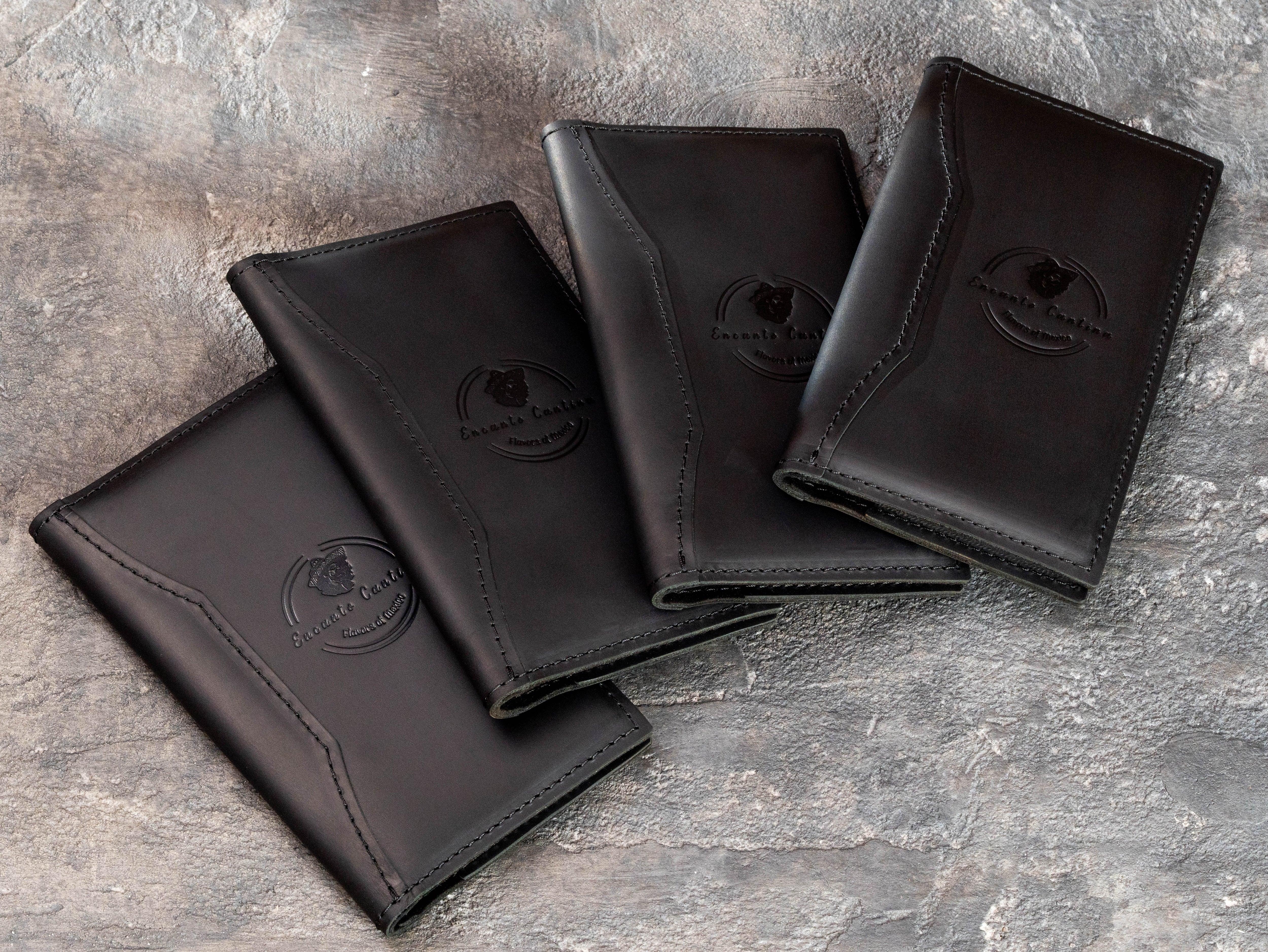 Bulk order of custom black leather check presenters for Encanto Cantina