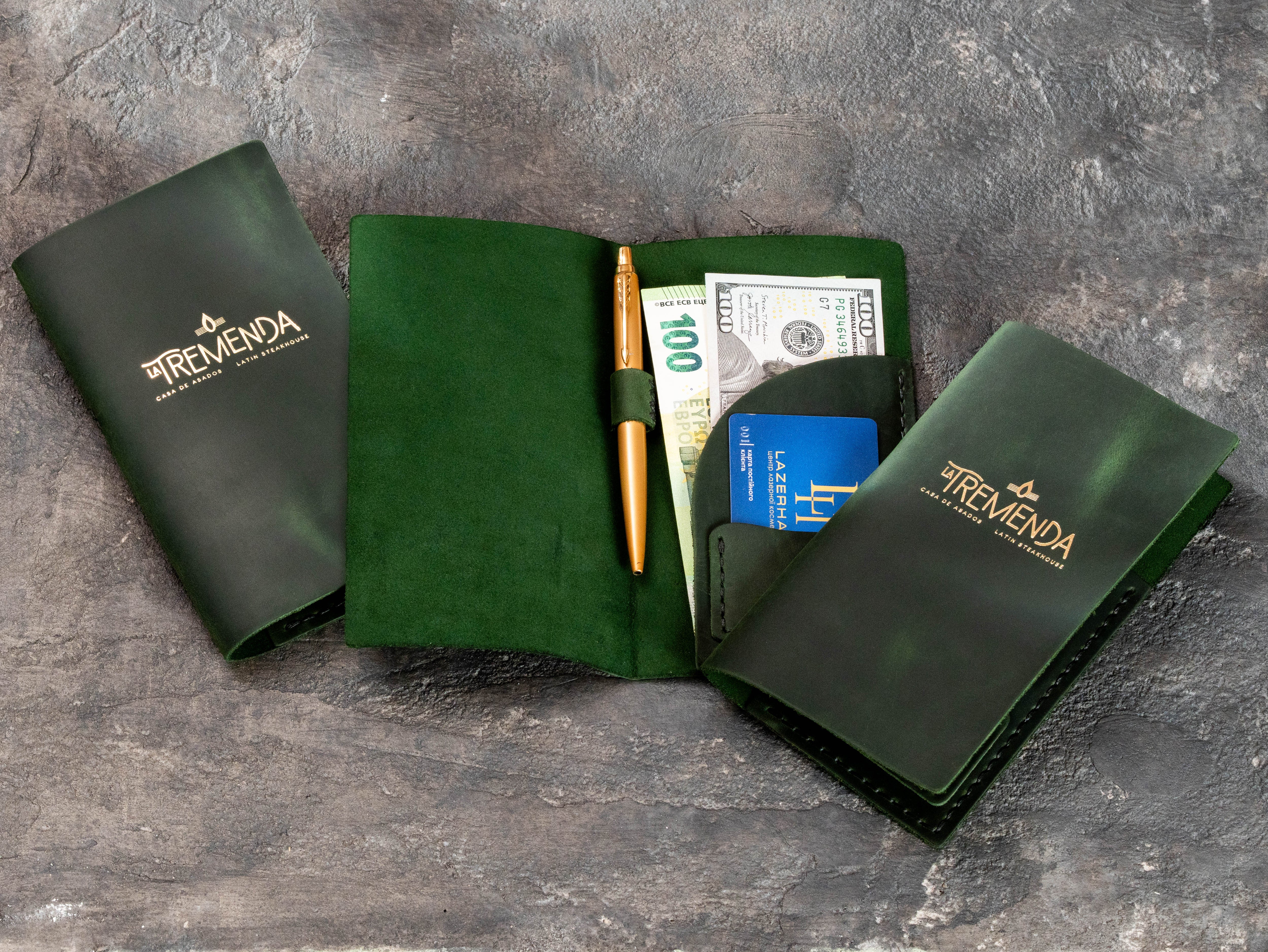 Custom green leather restaurant bill holders with gold logo and functional interior pockets