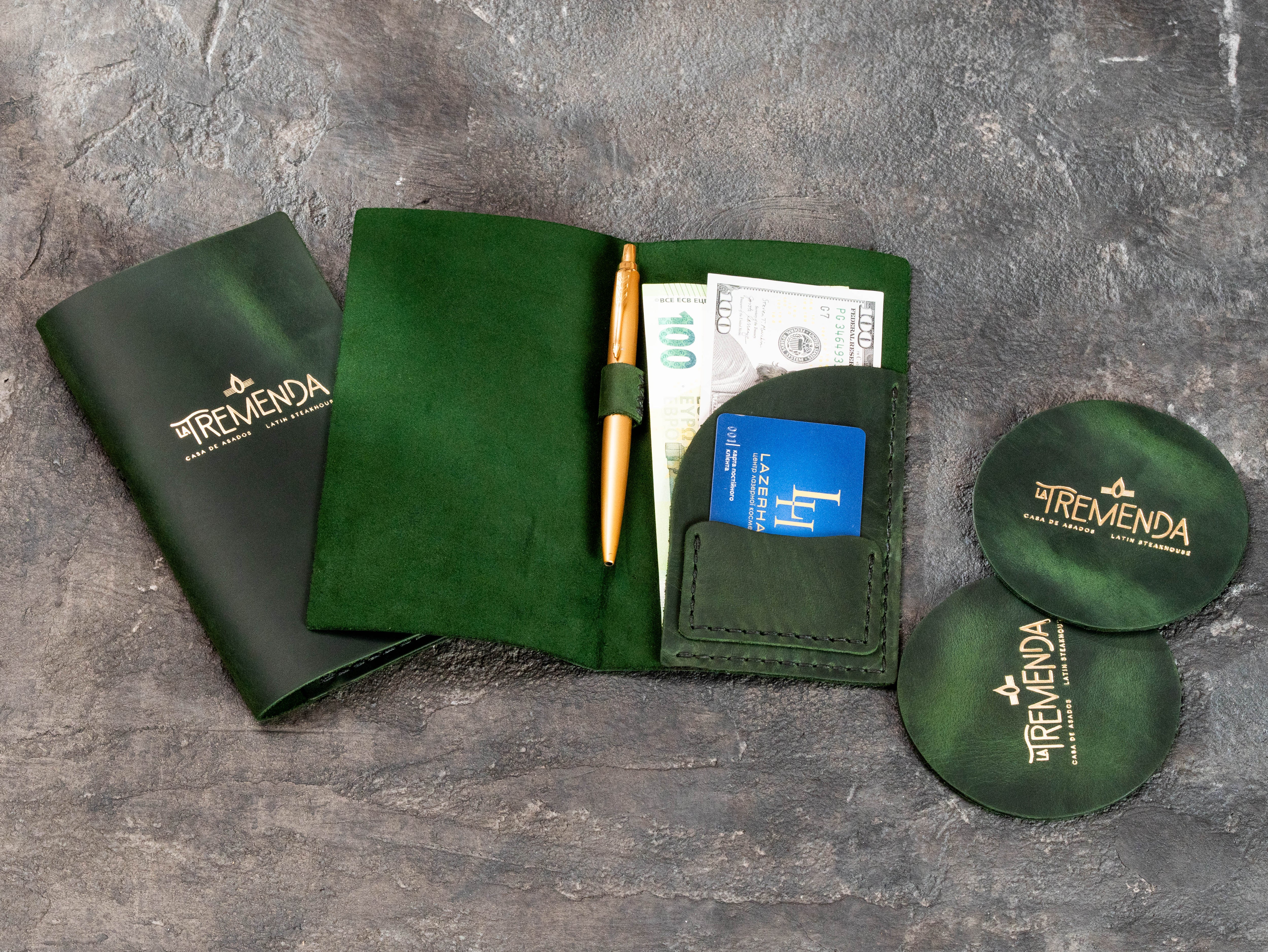 Custom leather restaurant check presenter and coasters in dark green with gold logo