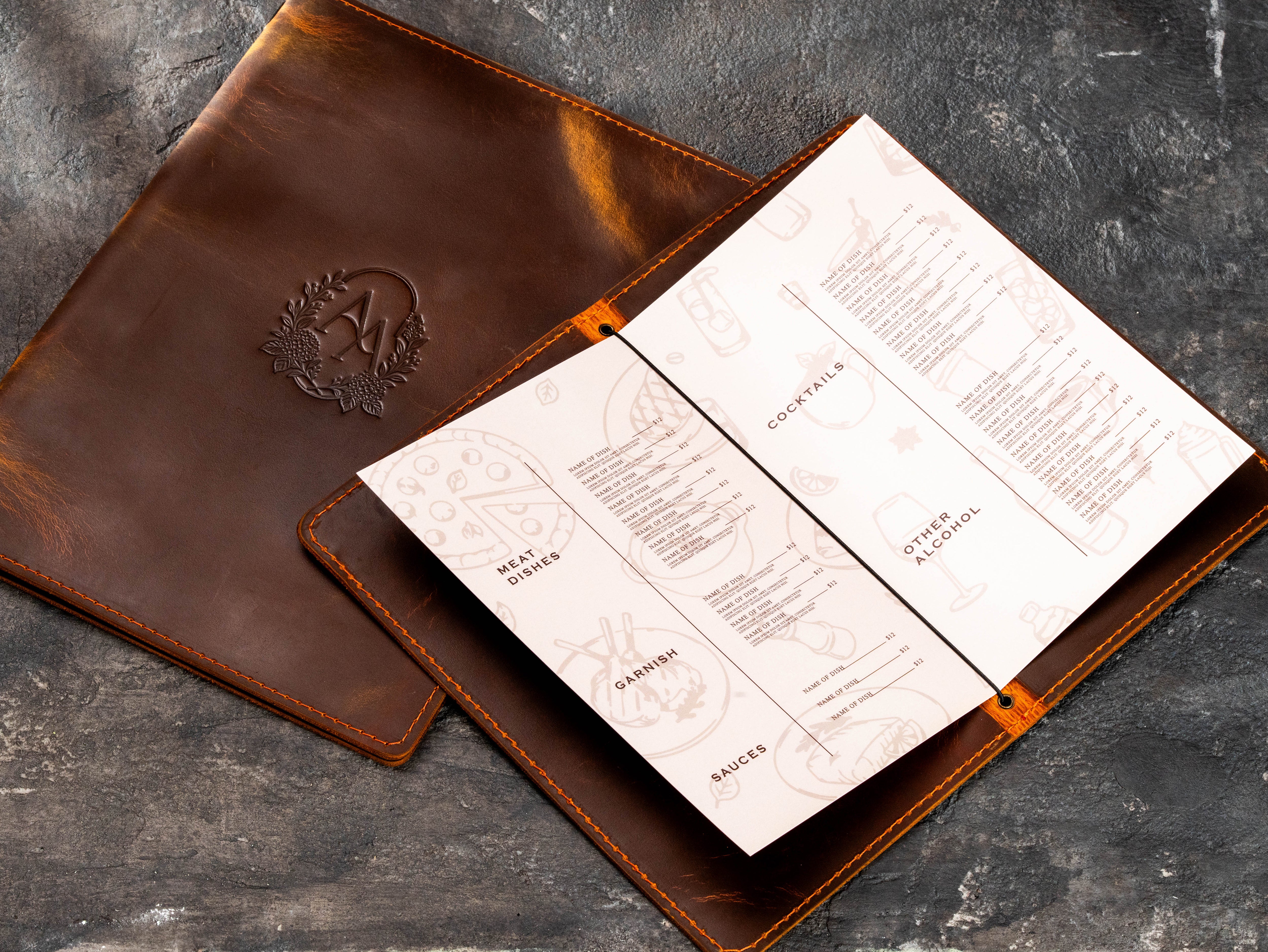 Open brown leather menu folder with elastic cord holding folded cocktail and food menu sheets