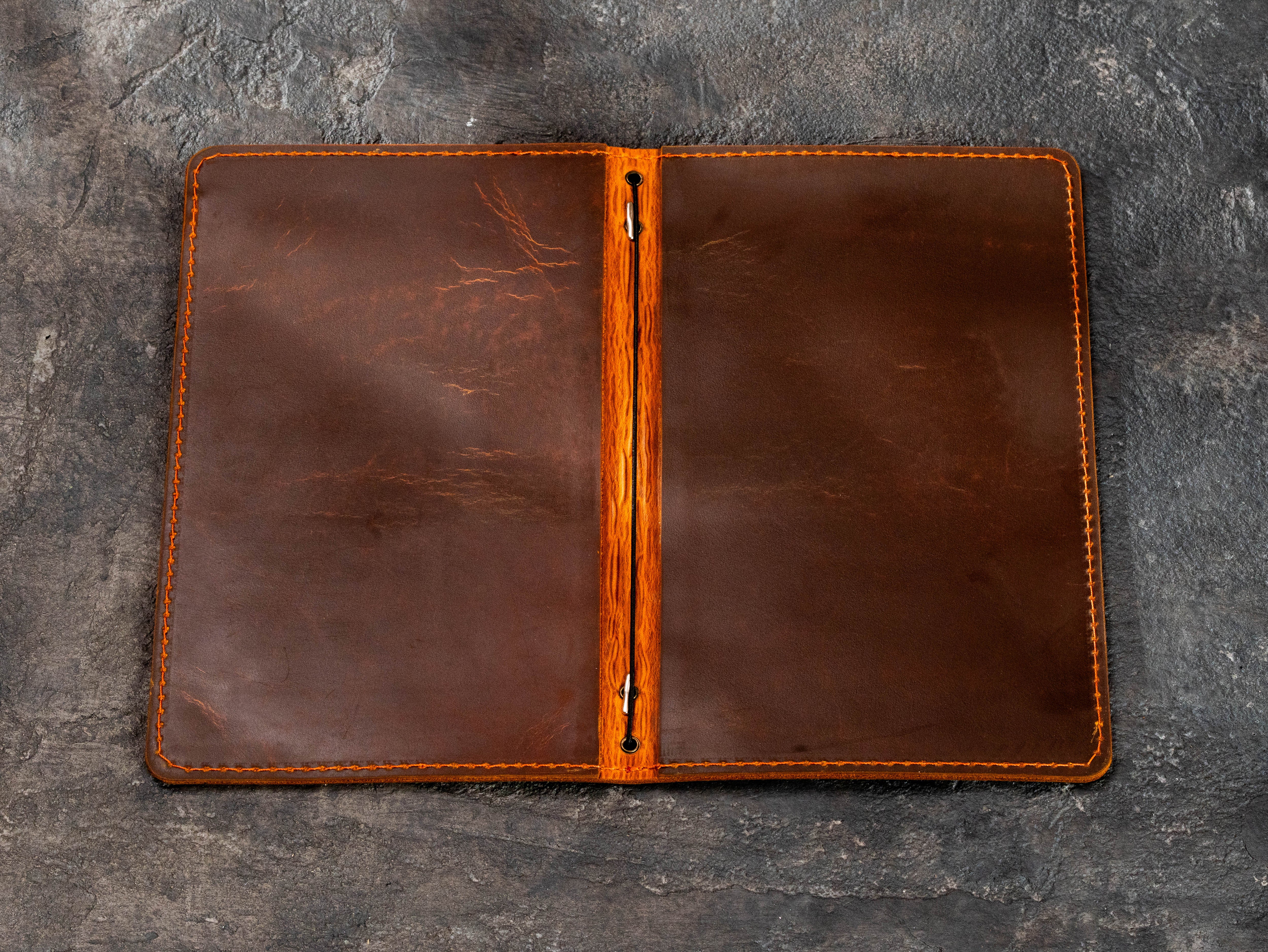 Open brown leather menu cover showing elastic cord binding for replaceable restaurant or home bar menus