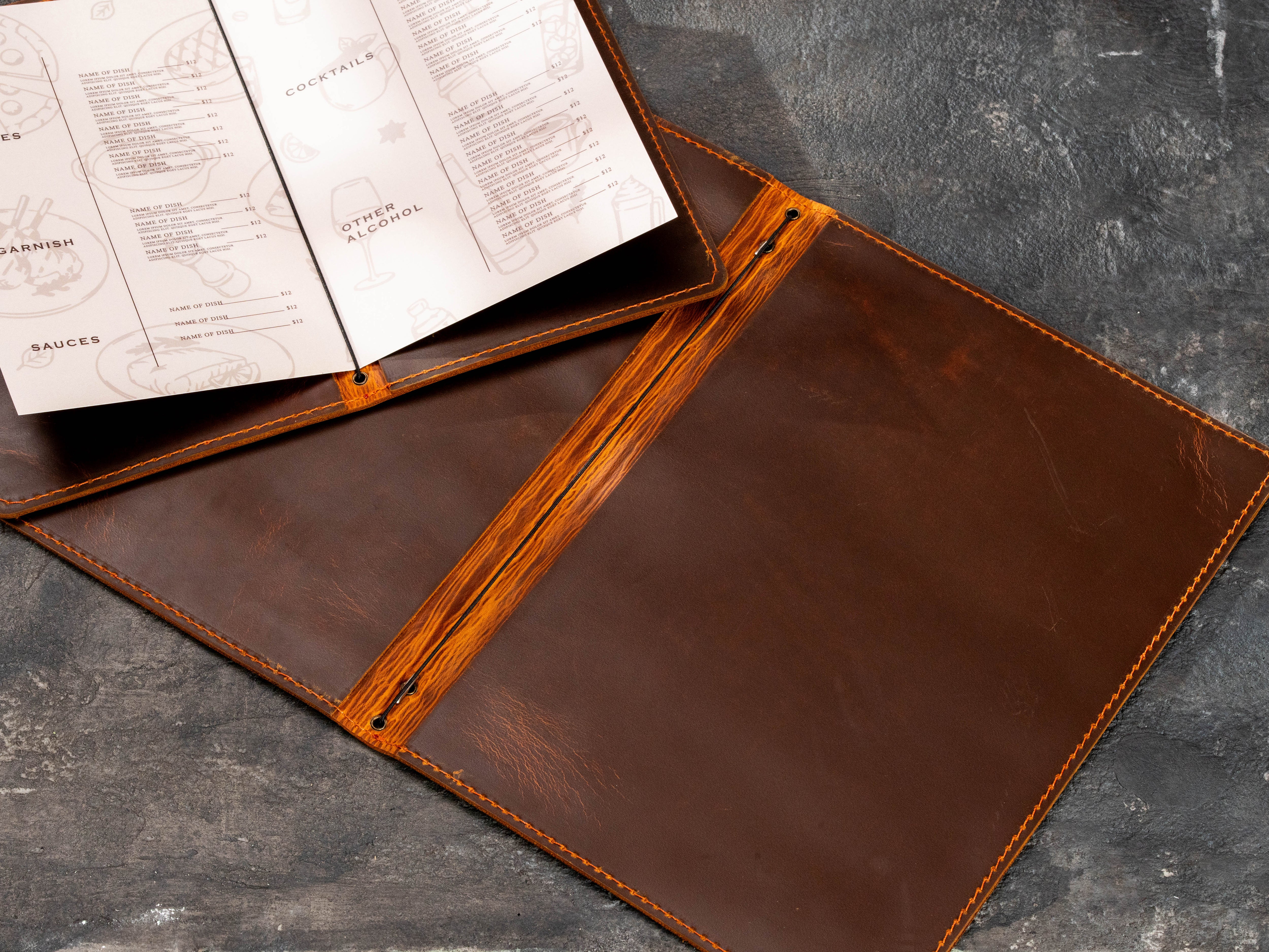 Two open brown leather menu folders with stitched edges and flexible elastic menu binding system