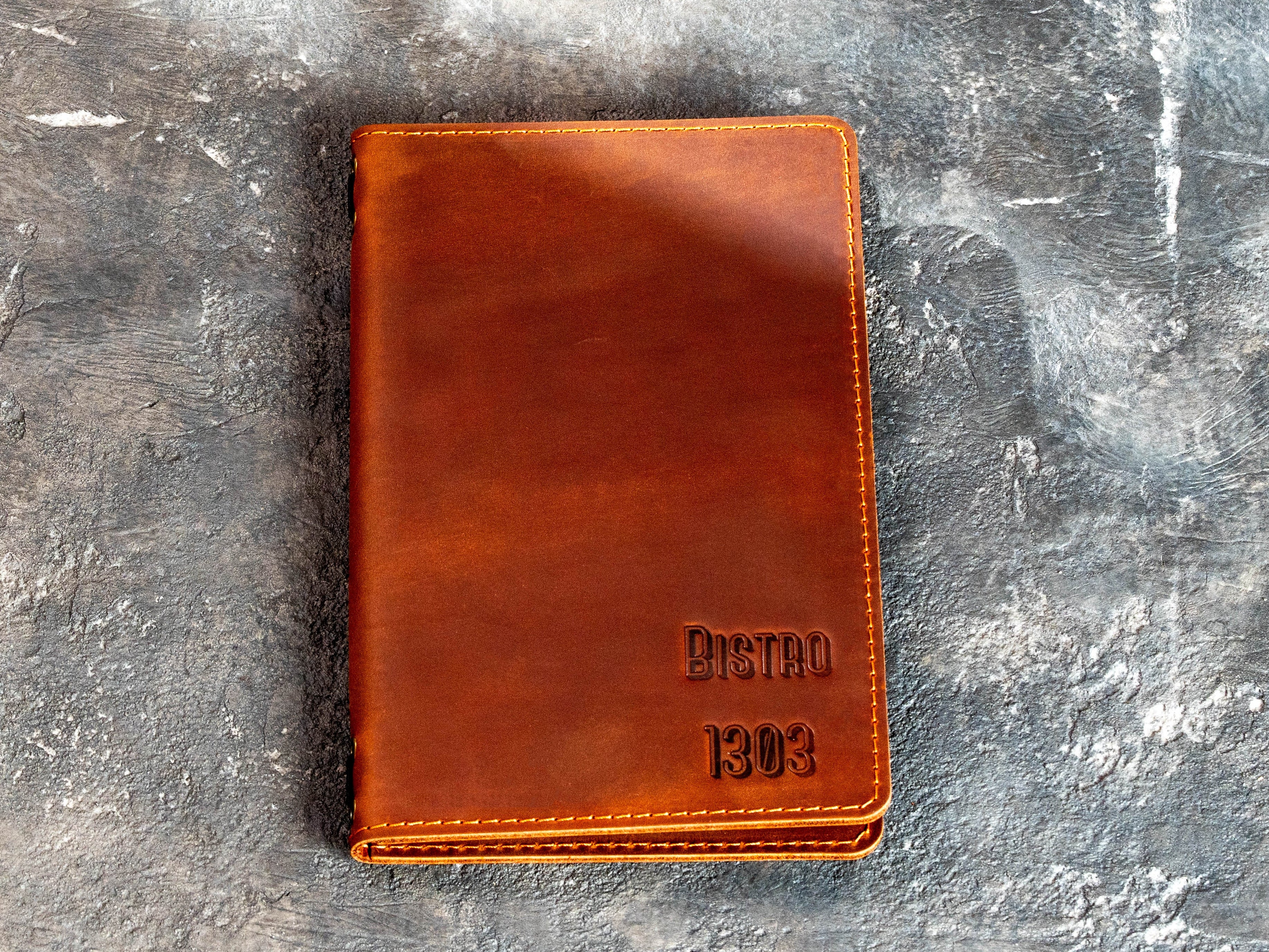 Chestnut leather restaurant menu cover with blind embossed Bistro 1303 logo
