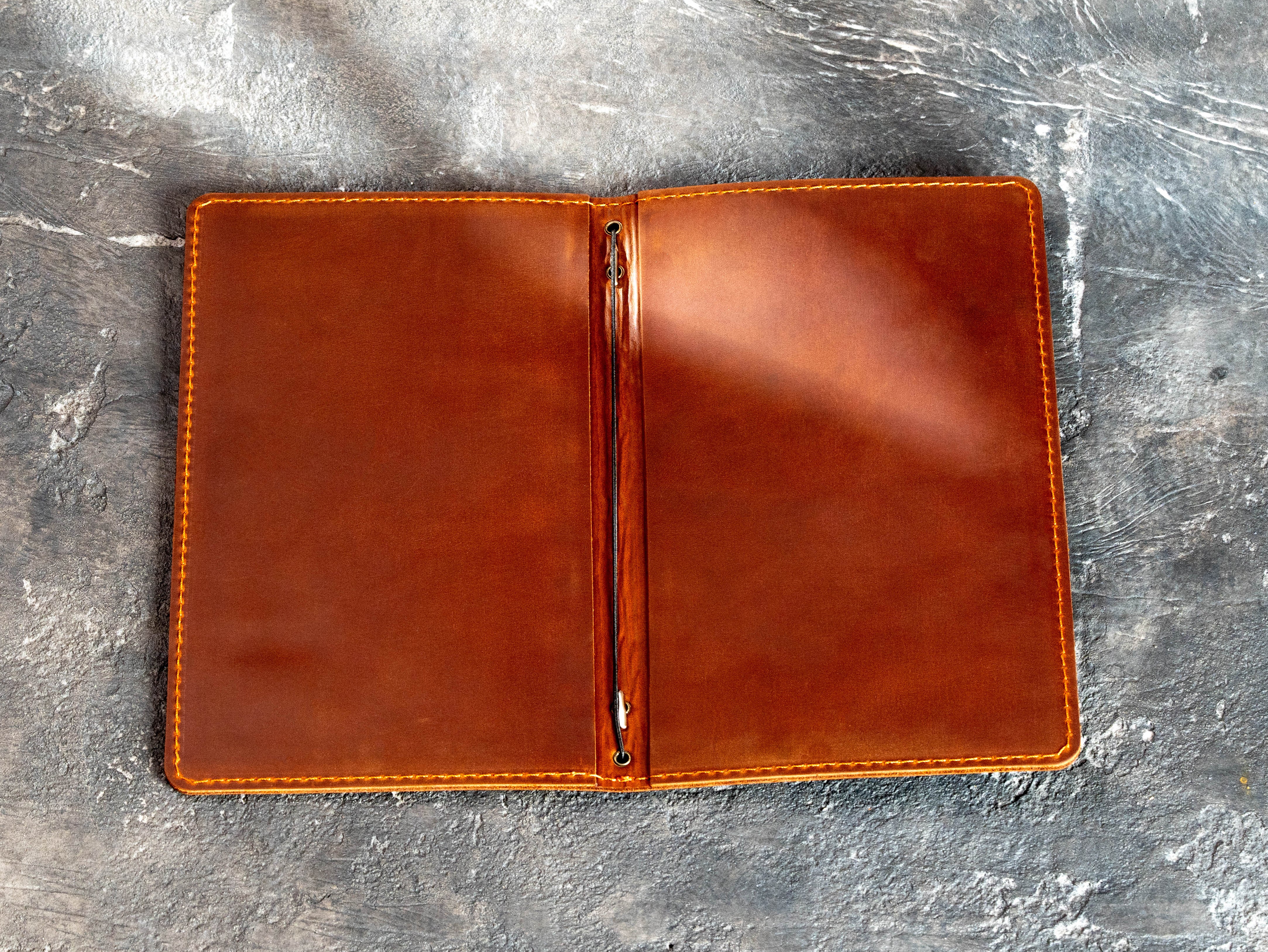 Open Bistro 1303 leather restaurant menu cover with printed pages secured by an elastic cord