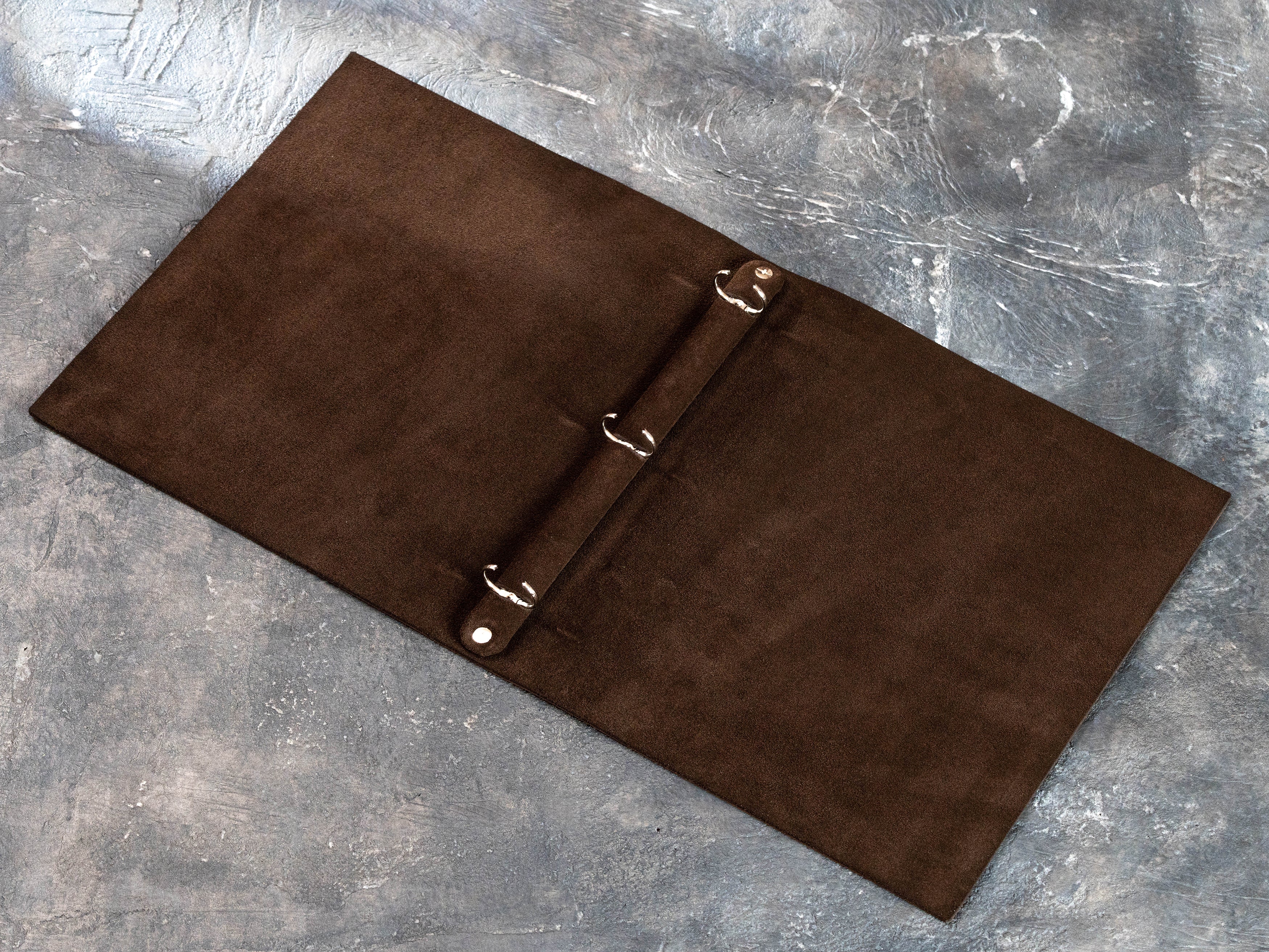 Open soft leather 3-ring binder with brown suede interior and round metal rings