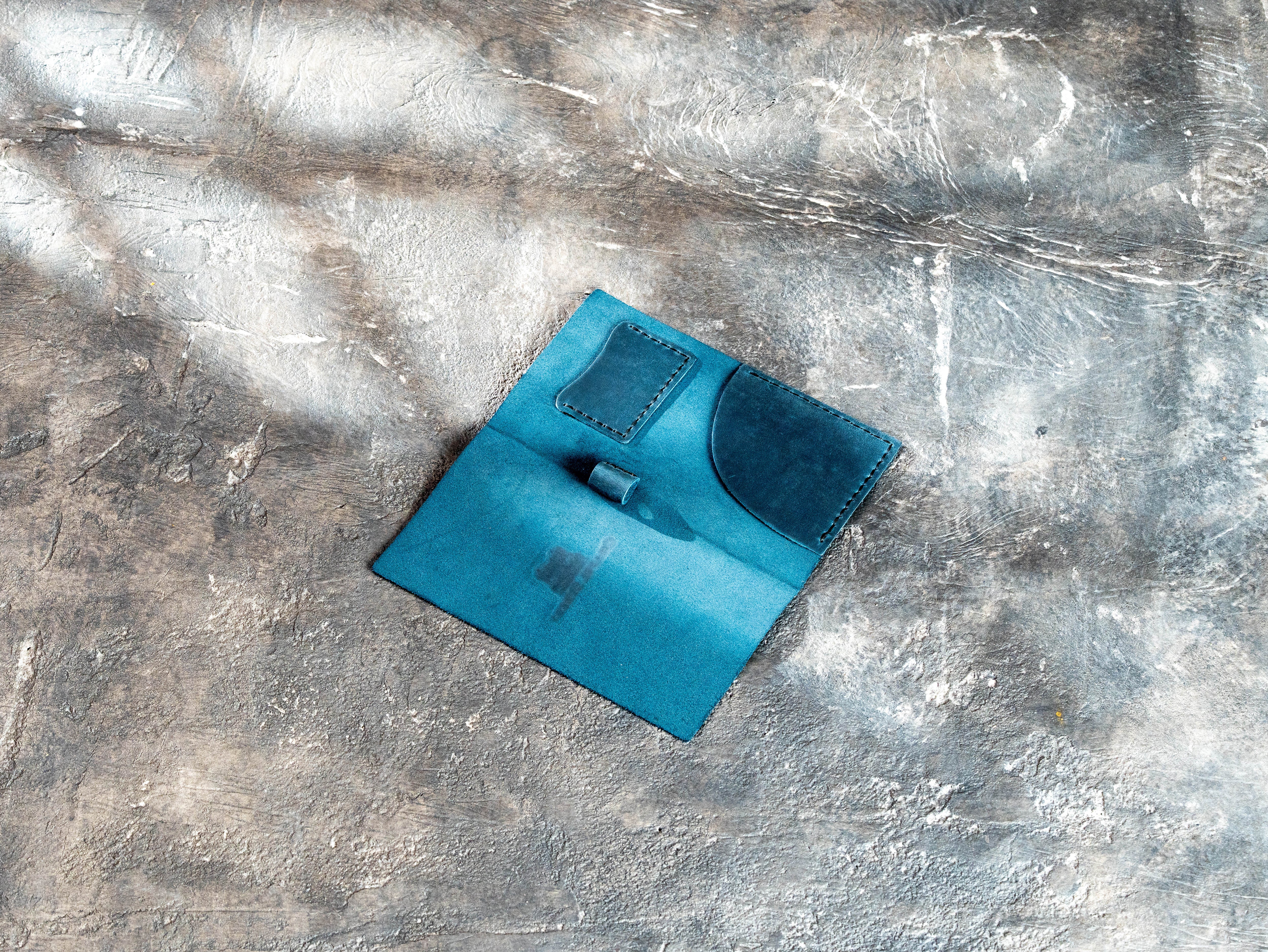 Open blue leather check presenter with receipt pocket, payment card holder, and pen loop