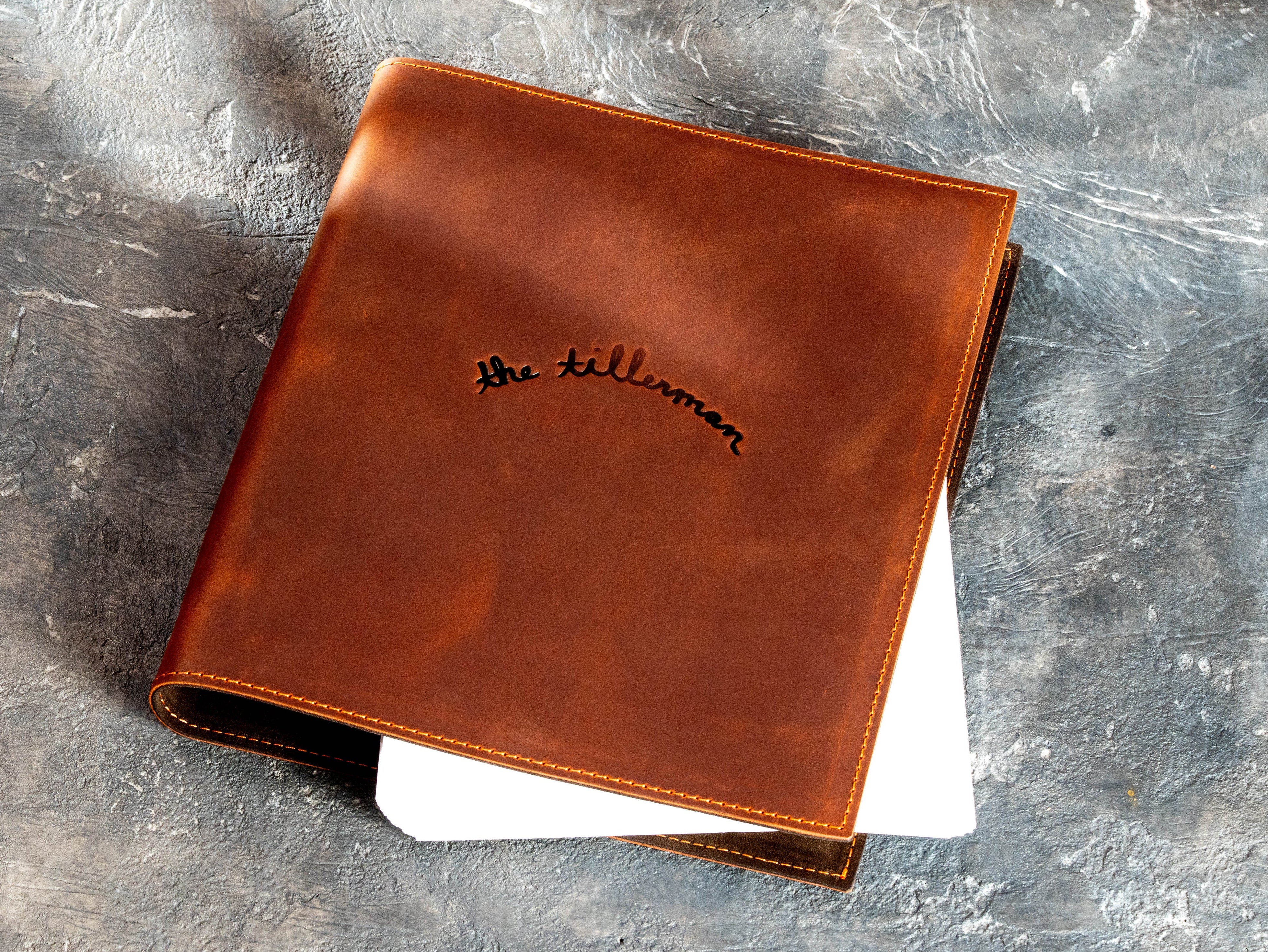 Custom copper leather 3-ring binder with The Tillerman logo and stitched rigid cover